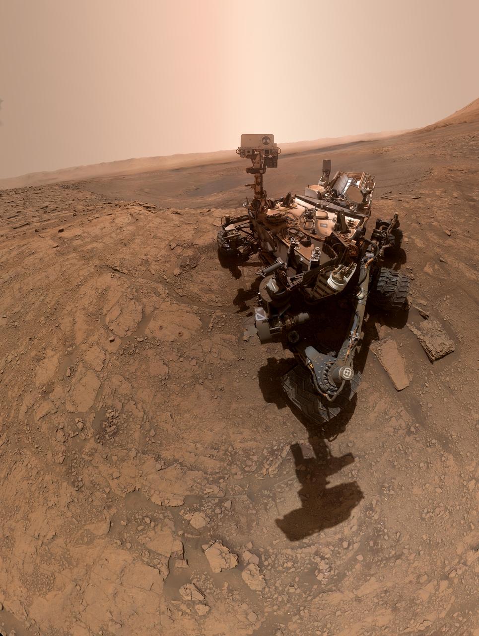 NASA's Curiosity rover took this selfie on Oct. 11, 2019, the 2,553rd Martian day, or sol, of its mission. The rover drilled twice in this location, nicknamed "Glen Etive" (pronounced "glen EH-tiv"). About 984 feet (300 meters) behind the rover, Vera Rubin Ridge rises up. Behind it lies the floor of Gale Crater, which Curiosity is exploring, and the northern rim of the crater. Just left of the rover are the two drill holes, called "Glen Etive 1" (right) and "Glen Etive 2" (left). Curiosity performed its first wet-chemistry experiment on a drilled sample at this location. The rover can analyze the chemical composition of rock samples by powderizing them with the drill, then dropping the samples into a portable lab in its belly called Sample Analysis at Mars (SAM). This panorama is made up of 57 individual images taken by the Mars Hand Lens Imager (MAHLI), a camera on the end of the rover's robotic arm. The images are stitched together into a panorama; the robotic arm isn't visible in the parts of the images used in the composite. https://photojournal.jpl.nasa.gov/catalog/PIA23378