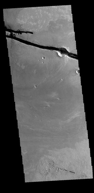 The linear depressions at the top of the VIS image are some of the graben that comprise Cerberus Fossae. Graben form where extensional tectonic forces allows blocks of material to subside between paired faults. Cerberus Fossae are located in Elysium Planitia, southeast of the Elysium Mons volcanic complex. The graben were also the source of significant volcanic flows, creating the deposits seen at the lower part of the image. Orbit Number: 77985 Latitude: 9.97726 Longitude: 157.285 Instrument: VIS Captured: 2019-07-14 14:21 https://photojournal.jpl.nasa.gov/catalog/PIA23400
