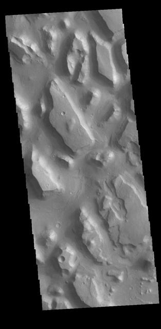 This VIS image shows part of Chryse Chaos near the terminal end of the huge outflow channels draining from Valles Marineris into the Chyrse Basin. Chaos terrain is typified by regions of blocky, often steep sided, mesas interspersed with deep valleys. With time and erosion the valleys widen and the mesas become smaller. It has been proposed that a catastrophic outflow of subsurface water creates the chaos and provides the surface flow creating the channel. Chaos terrain is also found along the course of most of channels in this region and may occur where the channel flow fluid warms the subsurface ice creating additional release points for melted subsurface ice. The chaos terrain in this image still retain the classic steep sided large mesas. Orbit Number: 78179 Latitude: 13.0698 Longitude: 319.552 Instrument: VIS Captured: 2019-07-30 13:47 https://photojournal.jpl.nasa.gov/catalog/PIA23419