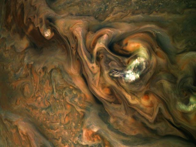 This view from NASA's Juno spacecraft captures colorful, intricate patterns in a jet stream region of Jupiter's northern hemisphere known as "Jet N3." Jupiter's cloud tops do not form a simple, flat surface. Data from Juno helped scientists discover that the swirling bands in the atmosphere extend deep into the planet, to a depth of about 1,900 miles (3,000 kilometers). At center right, a patch of bright, high-altitude "pop-up" clouds rises above the surrounding atmosphere. Citizen scientist Gerald Eichstädt created this enhanced-color image using data from the spacecraft's JunoCam imager. The original image was taken on May 29, 2019, at 1:01 a.m. PDT (4:01 a.m. EDT) as the Juno spacecraft performed its 20th close flyby of Jupiter. At the time the image was taken, the spacecraft was about 6,000 miles (9,700 kilometers) from the tops of the clouds, at a latitude of 39 degrees north. PIA23439 - Enhanced image by Gerald Eichstädt based on images provided courtesy of NASA/JPL-Caltech/SwRI/MSSS