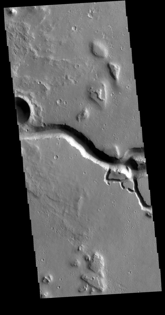 This VIS image is located in the southeastern portion of Hephaestus Fossae. Hephaestus Fossae is a complex channel system in Utopia Planitia near Elysium Mons. It has been proposed that the channel formed by the release of melted subsurface ice during the impact event that created a large crater west of this image. Additionally, the nearby Elysium volcanic center created subsurface heating that may have played a part in creating both Hephaestus Fossae and Hebrus Valles to the north. Hephaestus Fossae are over 600km long (373 miles). Orbit Number: 78847 Latitude: 17.5748 Longitude: 126.158 Instrument: VIS Captured: 2019-09-23 13:59 https://photojournal.jpl.nasa.gov/catalog/PIA23507