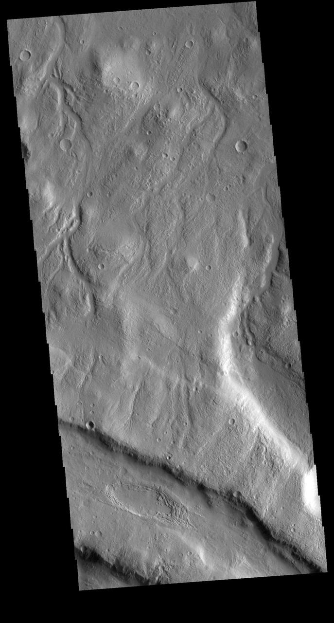 This VIS image shows part of the northern margin of Acheron Fossae. Multiple channels dissect the the higher elevation graben features at the bottom of the image. This higher topography feature is surrounded by lava flows and is thought to predate the majority of volcanic activity in the Tharsis region. Acheron Fossae is located 1,050 kilometers (650 miles) north of the large shield volcano Olympus Mons.  Orbit Number: 79093 Latitude: 39.3864 Longitude: 225.573 Instrument: VIS Captured: 2019-10-13 20:15  https://photojournal.jpl.nasa.gov/catalog/PIA23566