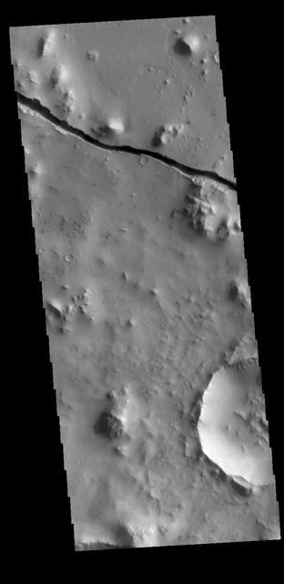 The linear depression in today's VIS image is part of Cerberus Fossae. The feature is termed a graben and was formed by crustal extension that allowed material to subside between paired tectonic faults. The straight sides and uniform depths are indications that this is tectonic feature rather than a channel caused by fluid erosion. Orbit Number: 79345 Latitude: 9.14199 Longitude: 159.698 Instrument: VIS Captured: 2019-11-03 14:06 https://photojournal.jpl.nasa.gov/catalog/PIA23657