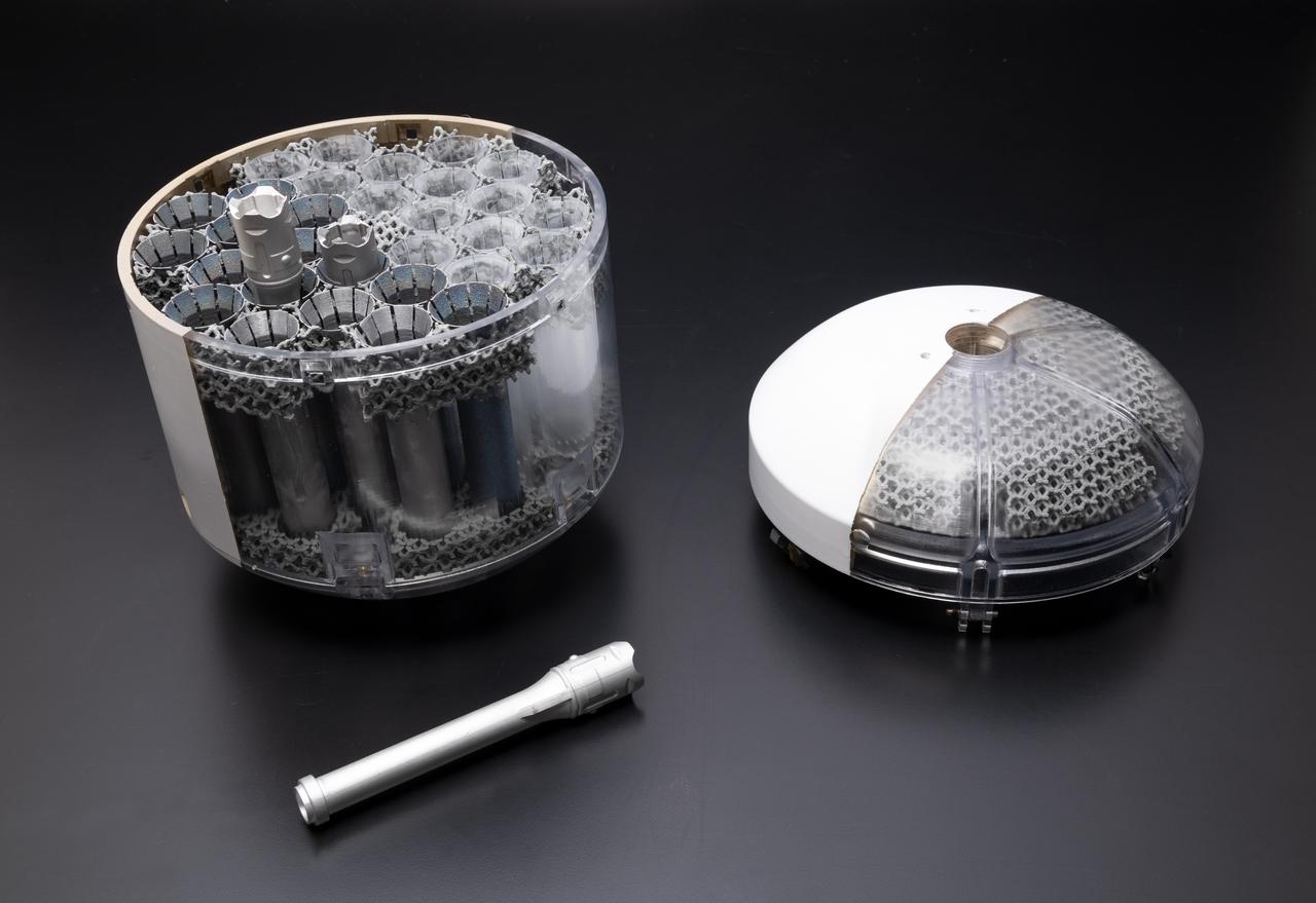 This image shows a concept model of NASA's orbiting sample container, which will hold tubes of Martian rock and soil samples that will be returned to Earth through a Mars sample return campaign. At right is the lid; bottom left sits a model of the sample-holding tube. The sample container will help keep contents at less than about 86 degrees Fahrenheit (30 degrees Celsius) to help preserve the Mars material in its most natural state.      NASA and the European Space Agency (ESA) are solidifying concepts for a Mars sample return mission after NASA's Mars 2020 rover collects rock and soil samples and stores them in sealed tubes on the planet's surface for future return to Earth.      In the new campaign, NASA will deliver a Mars lander in the vicinity of Jezero Crater, where Mars 2020 will have collected and cached samples. The lander will carry a NASA rocket (the Mars Ascent Vehicle) along with an ESA Sample Fetch Rover that is roughly the size of NASA's Opportunity Mars rover. The fetch rover will gather the cached samples and carry them back to the lander for transfer to an orbiting sample container embedded in the ascent vehicle; additional samples could also be delivered directly by Mars 2020. The ascent vehicle will then launch the container holding the samples into Mars orbit.      ESA will put a spacecraft in orbit around Mars before the ascent vehicle launches. This spacecraft will rendezvous with the orbiting sample container and also carry a NASA payload that can capture and contain the sample container before returning the samples to Earth.  https://photojournal.jpl.nasa.gov/catalog/PIA23712