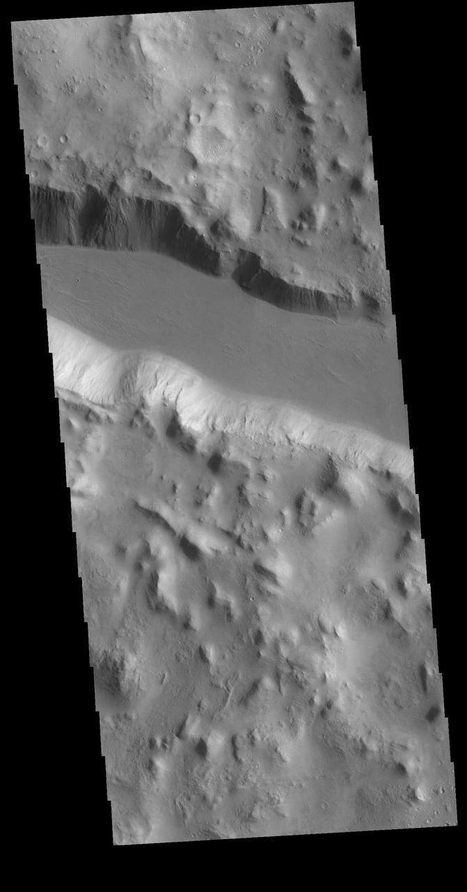 This VIS image shows one of the linear depressions of Cerberus Fossae. This feature is called a graben and is formed by extensional tectonic forces. As the regional fractures move apart, blocks of material slide down between paired faults. Orbit Number: 80106 Latitude: 13.7626 Longitude: 164.573 Instrument: VIS Captured: 2020-01-05 05:59 https://photojournal.jpl.nasa.gov/catalog/PIA23754