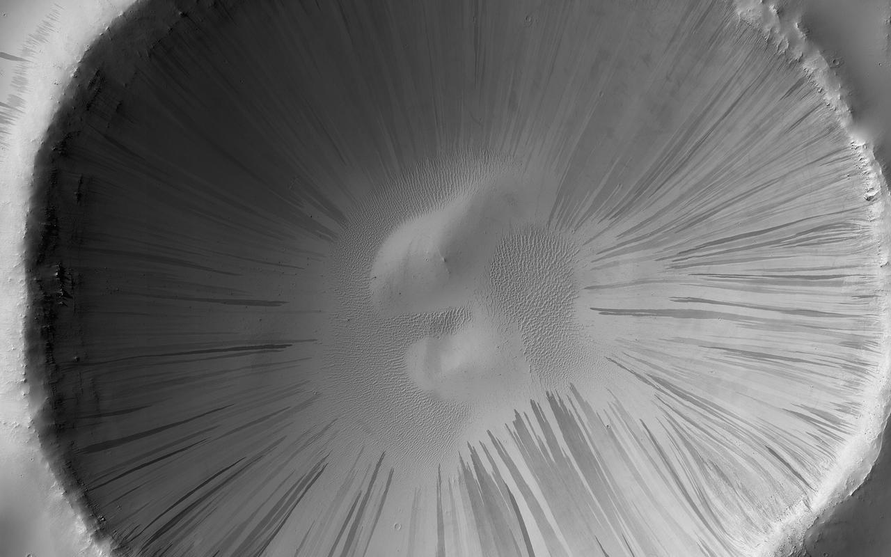 Dust and sand slide down slopes on Mars in little avalanches. Dark slope streaks are thought to be the result of the relatively bright colored dust avalanching down slopes, revealing the darker, coarser sand underneath.  This image is the latest in a sequence of images of this crater that started in 2013. The goal is to watch the dusty slopes, and try to understand more about the processes that drive these little avalanches.  https://photojournal.jpl.nasa.gov/catalog/PIA23757