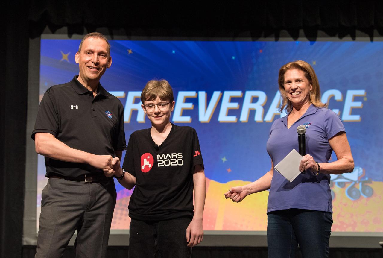 Lori Glaze, director of NASA's Planetary Science Division, looks on as Thomas Zurbuchen, associate administrator of NASA's Science Mission Directorate, congratulates Alexander Mather on March 5, 2020, during a celebration at Lake Braddock Secondary School in Burke, Virginia. The seventh grader had the honor of naming the agency's next Mars rover after submitting the winning entry to the agency's "Name the Rover" essay contest, which received 28,000 entrants from K-12 students from every U.S. state and territory.  https://photojournal.jpl.nasa.gov/catalog/PIA23762