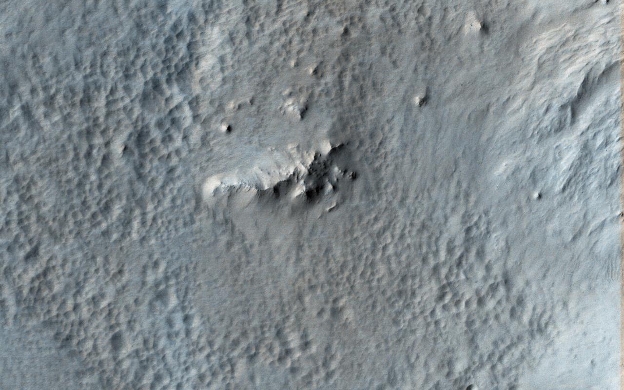 Tooting Crater is one of the youngest craters on Mars that is larger than 20-kilometers in diameter. Relatively low areas inside and outside the crater are covered by a distinctive pitted and ponded material. The pits are not impact craters, as they lack ejecta and are very closely spaced. There is one small impact crater near the lower right corner of our picture, which is much more circular than the pits and has a raised rim and ejecta. One interpretation is that this pitted and ponded material was hot impact ejecta from Tooting, and loss of volatiles from this material or underlying materials created the pits as it cooled. https://photojournal.jpl.nasa.gov/catalog/PIA23848