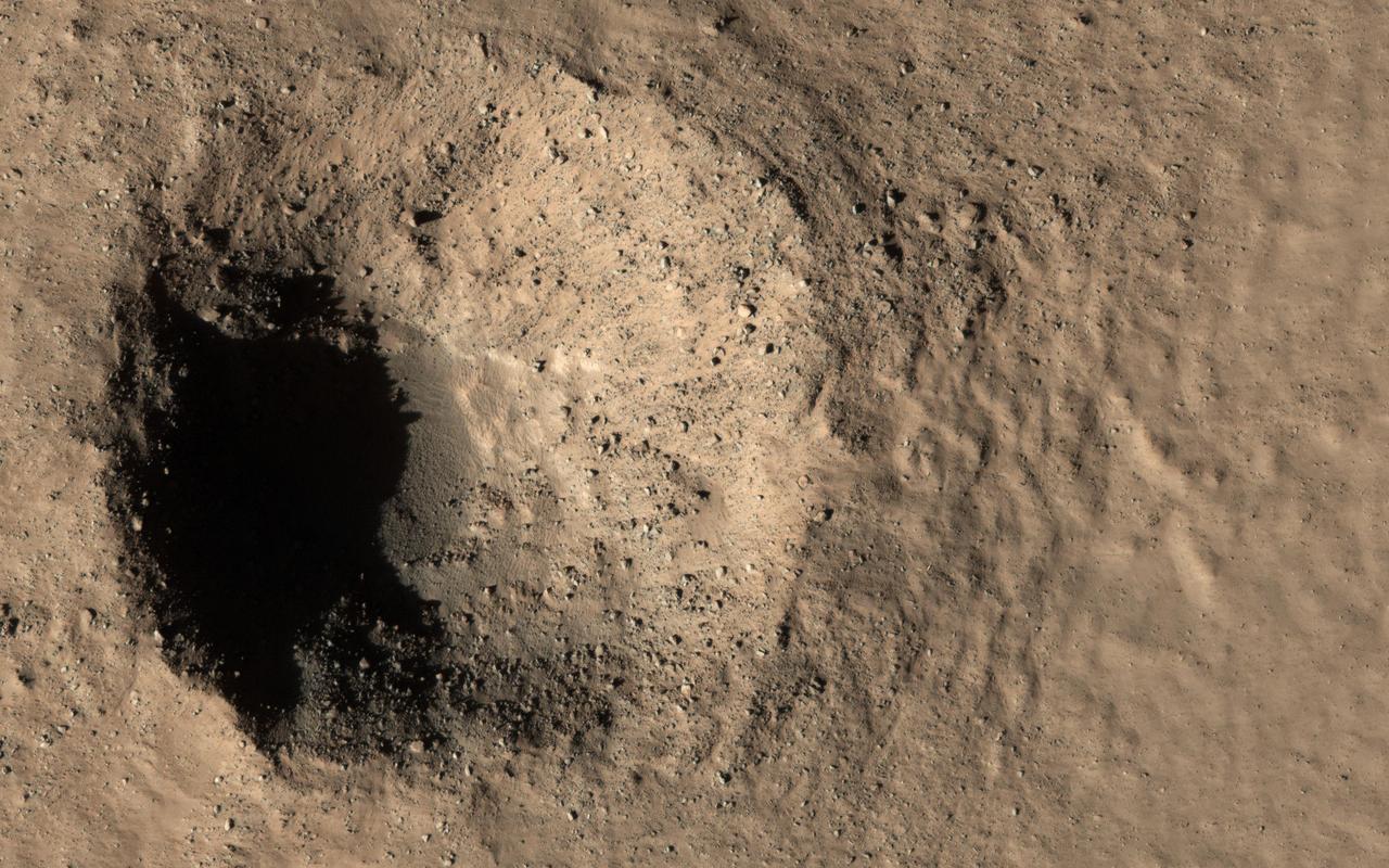 This image caught two different targets at once! In the top (northern) part there is a geologically-young crater about 300 meters in diameter, with rocky ejecta. The crater looks very fresh and steep and is not buried or filled in with the smooth deposits that cover the region. Craters like this tell us what is in the shallow subsurface and are very valuable for understanding the geology.  In the bottom (southern) part is a smaller crater, only about 15 meters across. This one is even younger, having formed between 2008 and 2010, when it was detected by MRO's Context Camera. The smaller crater exposed subsurface ice, and HiRISE has been re-imaging it to see how it changes as the ice slowly sublimates away. Compare this image to ESP_017926_2310 to see what has happened in the last decade!   https://photojournal.jpl.nasa.gov/catalog/PIA23852
