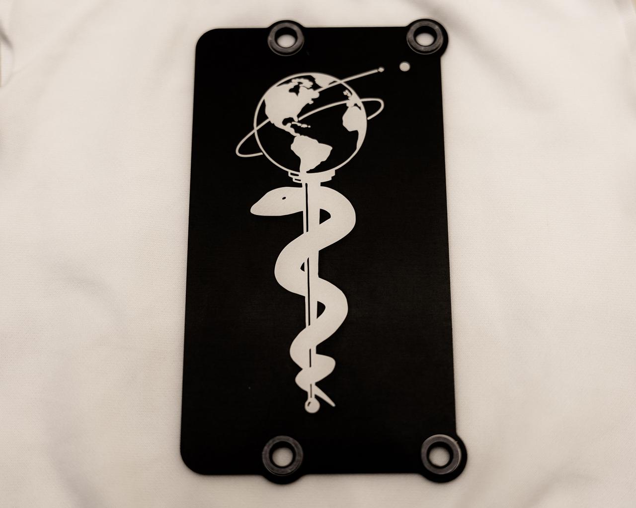 Members of NASA's Mars 2020 Perseverance rover mission installed a plate on the left side of the rover chassis, commemorating the impact of the COVID-19 pandemic and paying tribute to the perseverance of healthcare workers around the world. Made of aluminum, the 3-by-5-inch (8-by-13-centimeter) plaque was attached to the rover in May 2020 during final assembly at Kennedy Space Center in Florida.  https://photojournal.jpl.nasa.gov/catalog/PIA23921