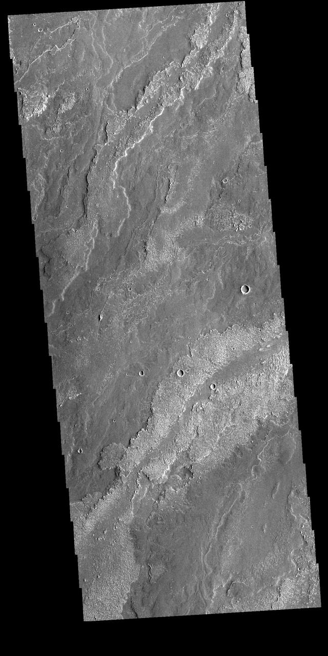 Today's VIS image shows part of the extensive lava flows that comprise Daedalia Planum. These flows originate at Arsia Mons, the southernmost of the three large aligned volcanoes in the Tharsis region of Mars. The different surface textures relate to properties like viscosity and temperature of the molten lava as it flowed and then cooled into solid rock. Orbit Number: 81052 Latitude: -21.9464 Longitude: 238.195 Instrument: VIS Captured: 2020-03-23 03:13 https://photojournal.jpl.nasa.gov/catalog/PIA23927
