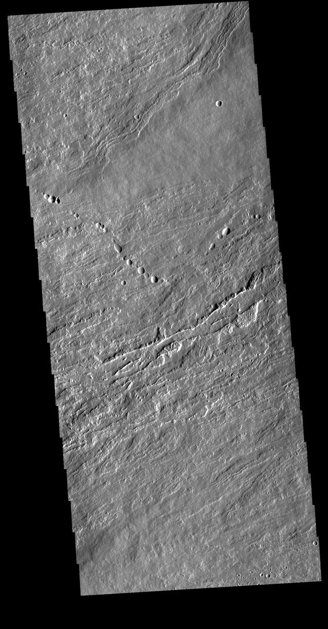 Today's VIS image shows flank flows on the east side of Olympus Mons. Olympus Mons stands 26 km (16 miles) above the surrounding plains, which is three times taller than Mt. Everest, and is the tallest volcano in the solar system. Olympus Mons is also wider (585 km, 363 miles) than the state of Arizona. Although these are impressive dimensions an astronaut would find walking these slopes easy, as they are typically only 2 to 5 degrees. This image contains numerous lava flows, leveed lava channels, and a series of round depressions thought to be where the roof of a lava tube has collapsed into the underlying void.  Orbit Number: 81077 Latitude: 19.9207 Longitude: 231.287 Instrument: VIS Captured: 2020-03-25 04:51  https://photojournal.jpl.nasa.gov/catalog/PIA23928