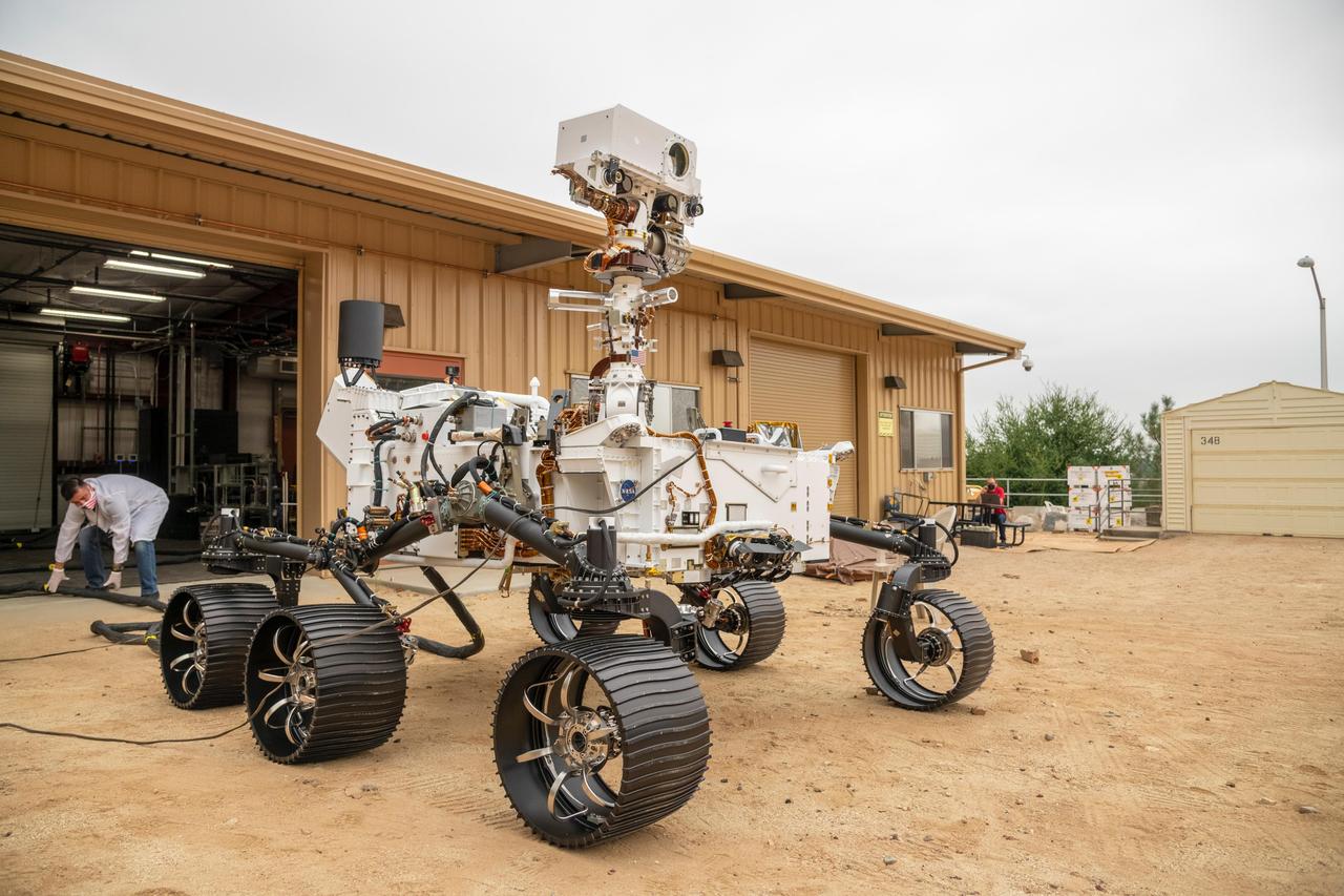 The full-scale engineering model of NASA's Perseverance rover has put some dirt on its wheels. This vehicle system test bed (VSTB) rover moved into its home — a garage facing the Mars Yard at NASA's Jet Propulsion Laboratory in Southern California — on Sept. 4, 2020. It drove onto simulated Martian surface of the Mars Yard — a dirt field at JPL studded with rocks and other obstacles — for the first time on Sept. 8. The VSTB rover is also known as OPTIMISM (Operational Perseverance Twin for Integration of Mechanisms and Instruments Sent to Mars).  A key objective for Perseverance's mission on Mars is astrobiology, including the search for signs of ancient microbial life. The rover will also characterize the planet's climate and geology, pave the way for human exploration of the Red Planet, and be the first planetary spacecraft to collect and cache Martian rock and regolith (broken rock and dust). Subsequent missions, currently under consideration by NASA in cooperation with the European Space Agency, would send spacecraft to Mars to collect these cached samples from the surface and return them to Earth for in-depth analysis.  The Mars 2020 mission is part of a larger program that includes missions to the Moon as a way to prepare for human exploration of the Red Planet. Charged with returning astronauts to the Moon by 2024, NASA will establish a sustained human presence on and around the Moon by 2028 through NASA's Artemis lunar exploration plans.  https://photojournal.jpl.nasa.gov/catalog/PIA23966