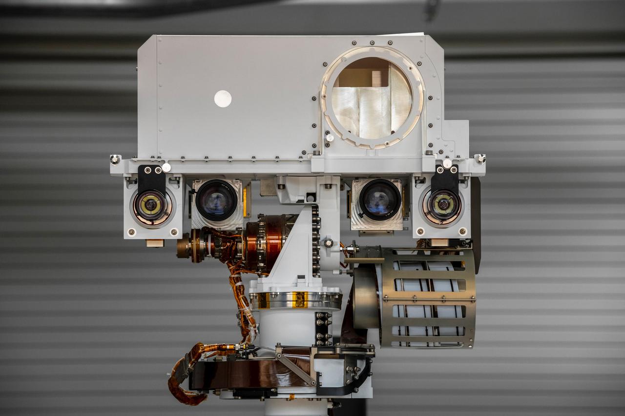The full-scale engineering model of NASA's Perseverance rover raises its "head," or remote sensing mast, at NASA's Jet Propulsion Laboratory in Southern California. This model is known as the vehicle system test bed (VSTB) rover, or OPTIMISM (Operational Perseverance Twin for Integration of Mechanisms and Instruments Sent to Mars). OPTIMISM raised its mast shortly after moving into its new home at JPL's Mars Yard on Sept. 4, 2020.  The mast hosts many of the rover's cameras and scientific instruments. At the top of the mast, the large circular opening is where the SuperCam instrument will be installed on this test rover. Also visible in these images below the SuperCam "eye" are the navigation cameras (two cameras closest to the outside of the head) and the Mastcam-Z cameras inside of the navigation cameras.  A key objective for Perseverance's mission on Mars is astrobiology, including the search for signs of ancient microbial life. The rover will also characterize the planet's climate and geology, pave the way for human exploration of the Red Planet, and be the first planetary spacecraft to collect and cache Martian rock and regolith (broken rock and dust). Subsequent missions, currently under consideration by NASA in cooperation with the European Space Agency, would send spacecraft to Mars to collect these cached samples from the surface and return them to Earth for in-depth analysis.  The Mars 2020 mission is part of a larger program that includes missions to the Moon as a way to prepare for human exploration of the Red Planet. Charged with returning astronauts to the Moon by 2024, NASA will establish a sustained human presence on and around the Moon by 2028 through NASA's Artemis lunar exploration plans.  https://photojournal.jpl.nasa.gov/catalog/PIA23967