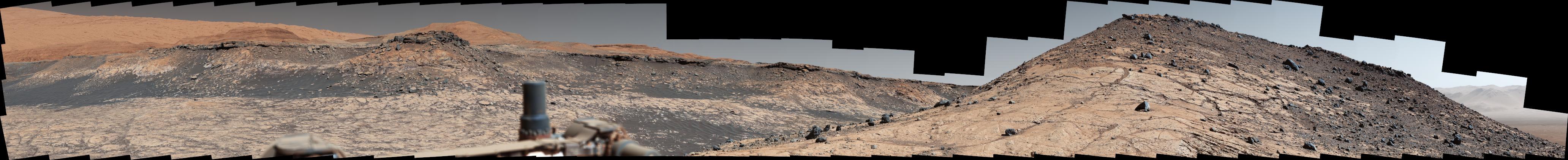 This wide panorama was taken by NASA's Curiosity Mars rover on Dec. 19, 2019, the 2,620th Martian day, or sol, of the mission. On the righthand foreground is Western Butte; the ridge with a crusty cap in the background is the Greenheugh pediment, which Curiosity ascended in March of 2020.  The rover's Mast Camera, or Mastcam, used its telephoto lens to produce the panorama, which includes 130 individual images stitched together. The panorama has been white-balanced so that the colors of the rock materials resemble how they would appear under daytime lighting conditions on Earth.  https://photojournal.jpl.nasa.gov/catalog/PIA23971