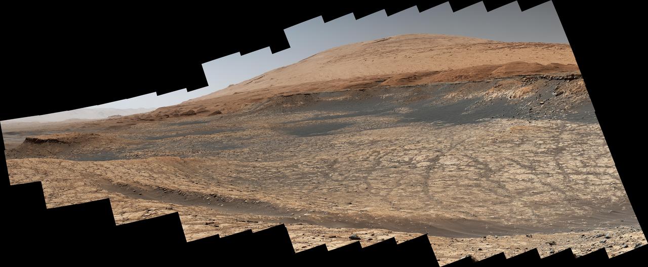 Stitched together from 116 images, this view captured by NASA's Curiosity Mars rover shows the path it will take in the summer of 2020 as it drives to the "sulfate-bearing unit," the next layer it will be investigating on the 3-mile-tall (5-kilometer-tall) Mount Sharp. Curiosity has to drive around a large sand patch in order to reach a place where it can ascend to the sulfate-rich region. The upper part of the mountain looms at the top image. The images were taken by the rover's Mast Camera, or Mastcam, on Jan. 10, 2020, the 2,641st Martian day, or sol, of the mission.  The panorama has been white-balanced so that the colors of the rock materials resemble how they would appear under daytime lighting conditions on Earth.  https://photojournal.jpl.nasa.gov/catalog/PIA23973