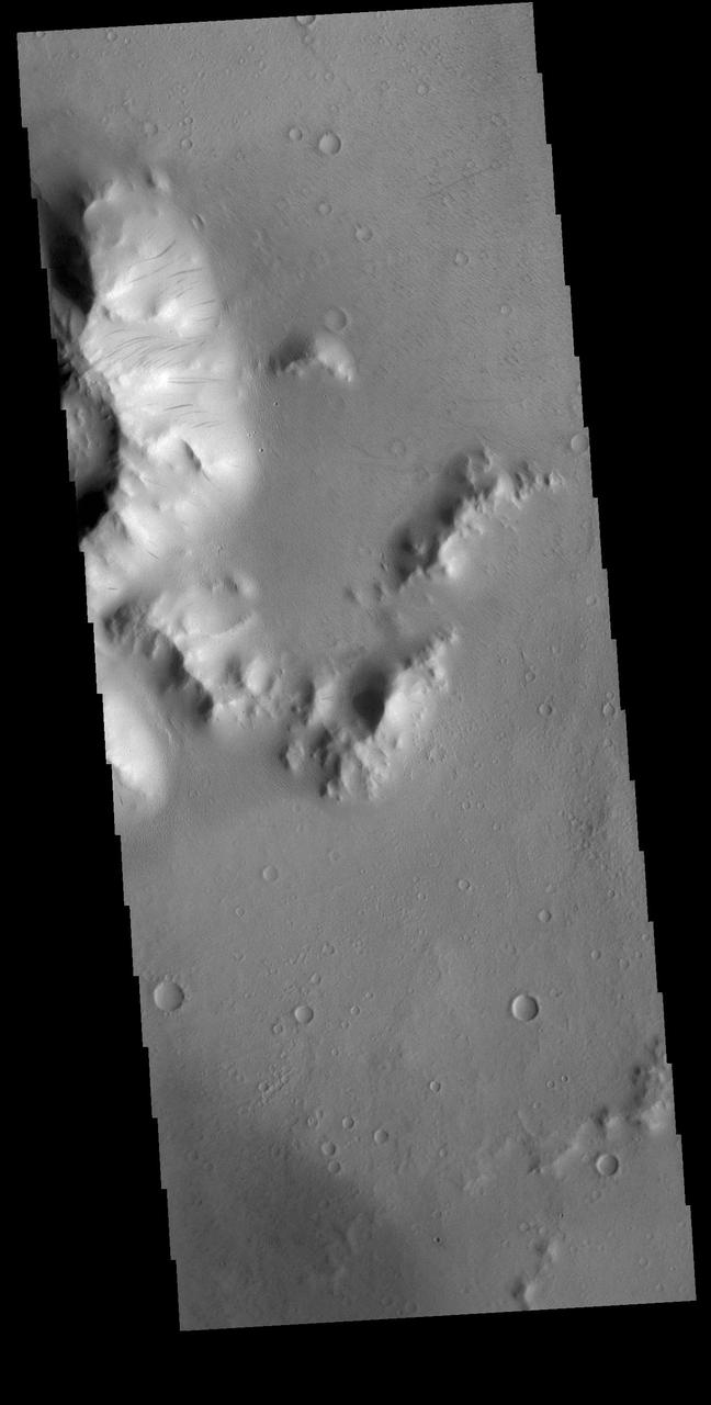 Today's VIS image covers part of the central peak and floor of Burton Crater. The central peak slopes are covered with numerous dark streaks. There are several suggested mechanisms to form these features. Two of the mechanisms are that the dusty surface has been altered to reveal darker rock beneath from motion of downward moving dust, or the surface is darkening by fluid or other surface staining. Orbit Number: 81727 Latitude: -14.0279 Longitude: 203.923 Instrument: VIS Captured: 2020-05-17 17:09 https://photojournal.jpl.nasa.gov/catalog/PIA24005