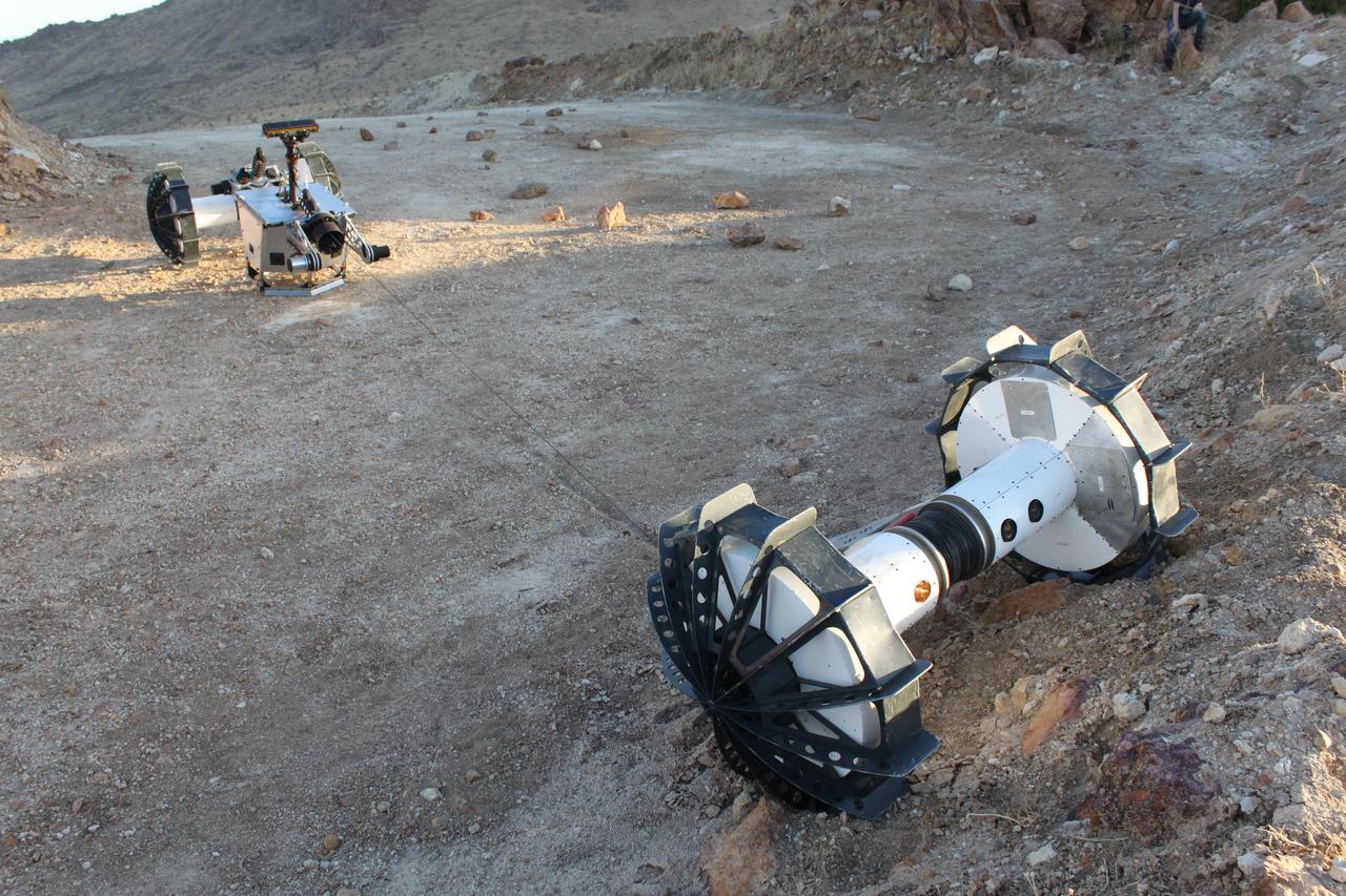 During a field test in the Mojave Desert, the DuAxel robot separates into two single-axled robots so that one can rappel down a slope too steep for conventional rovers. The tether connecting both Axels not only allows the one robot to descend the slope while the other remains anchored in place, it also provides power and a means of communication with the anchoring robot above. The DuAxel project is a technology demonstration being developed by roboticists at NASA's Jet Propulsion Laboratory in Southern California to see how this unconventional rover might fill a niche in the exploration the Moon, Mars, and beyond. https://photojournal.jpl.nasa.gov/catalog/PIA24109
