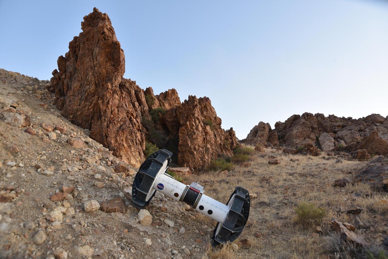 In this photograph, a tethered Axel robot — part of the four-wheeled DuAxel rover — navigates a steep slope during a field test in the Mojave Desert. The tether, which connects to the rover's other half, serves as a climbing rope of sorts while also providing power and a means of communication.  This flexibility was built with crater walls, pits, scarps, vents, and other extreme terrain in mind. That's because on Earth, some of the best locations to study geology can be found in rocky outcrops and cliff faces, where many layers of the past are neatly exposed. They're hard enough to reach here, let alone on the Moon, Mars, and other celestial bodies.  The DuAxel project is a technology demonstration being developed by roboticists at NASA's Jet Propulsion Laboratory in Southern California to see how this unconventional rover might fill a niche in planetary exploration.  https://photojournal.jpl.nasa.gov/catalog/PIA24110