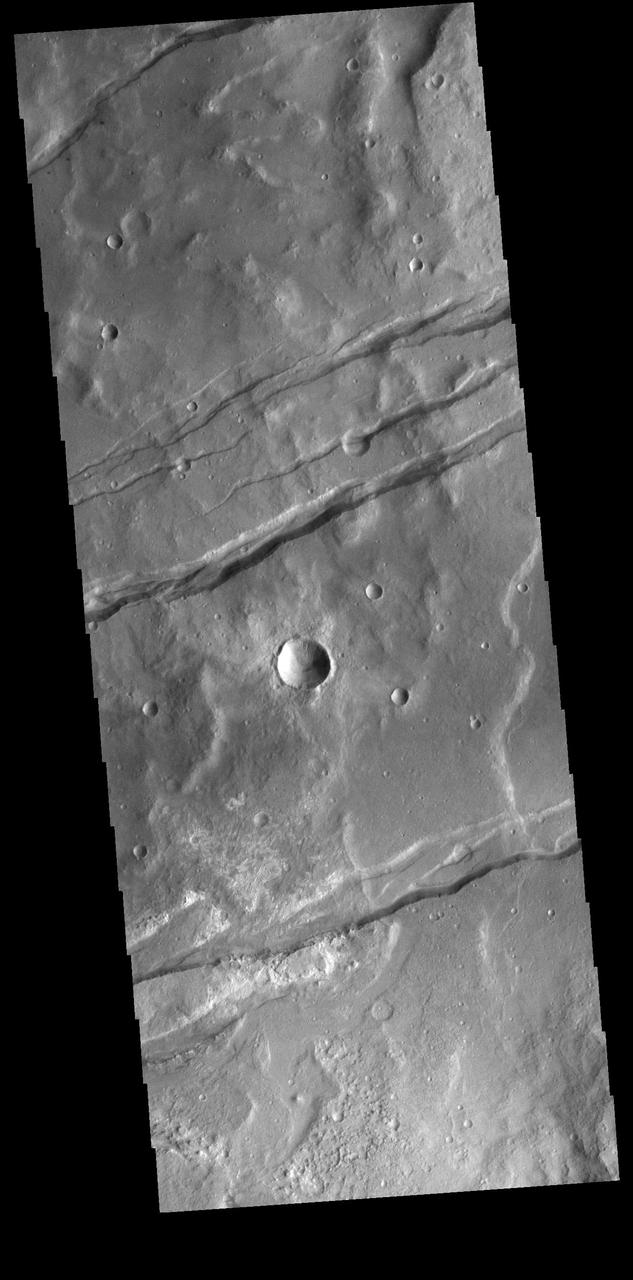 The linear depressions in this VIS image are part of Sirenum Fossae. These depressions are called graben, which form by the down drop of material between two parallel faults. The faults are caused by tectonic stresses in the region. The Sirenum Fossae graben are 2735km (1700 miles) long. Orbit Number: 82052 Latitude: -37.4717 Longitude: 191.302 Instrument: VIS Captured: 2020-06-13 11:16 https://photojournal.jpl.nasa.gov/catalog/PIA24118