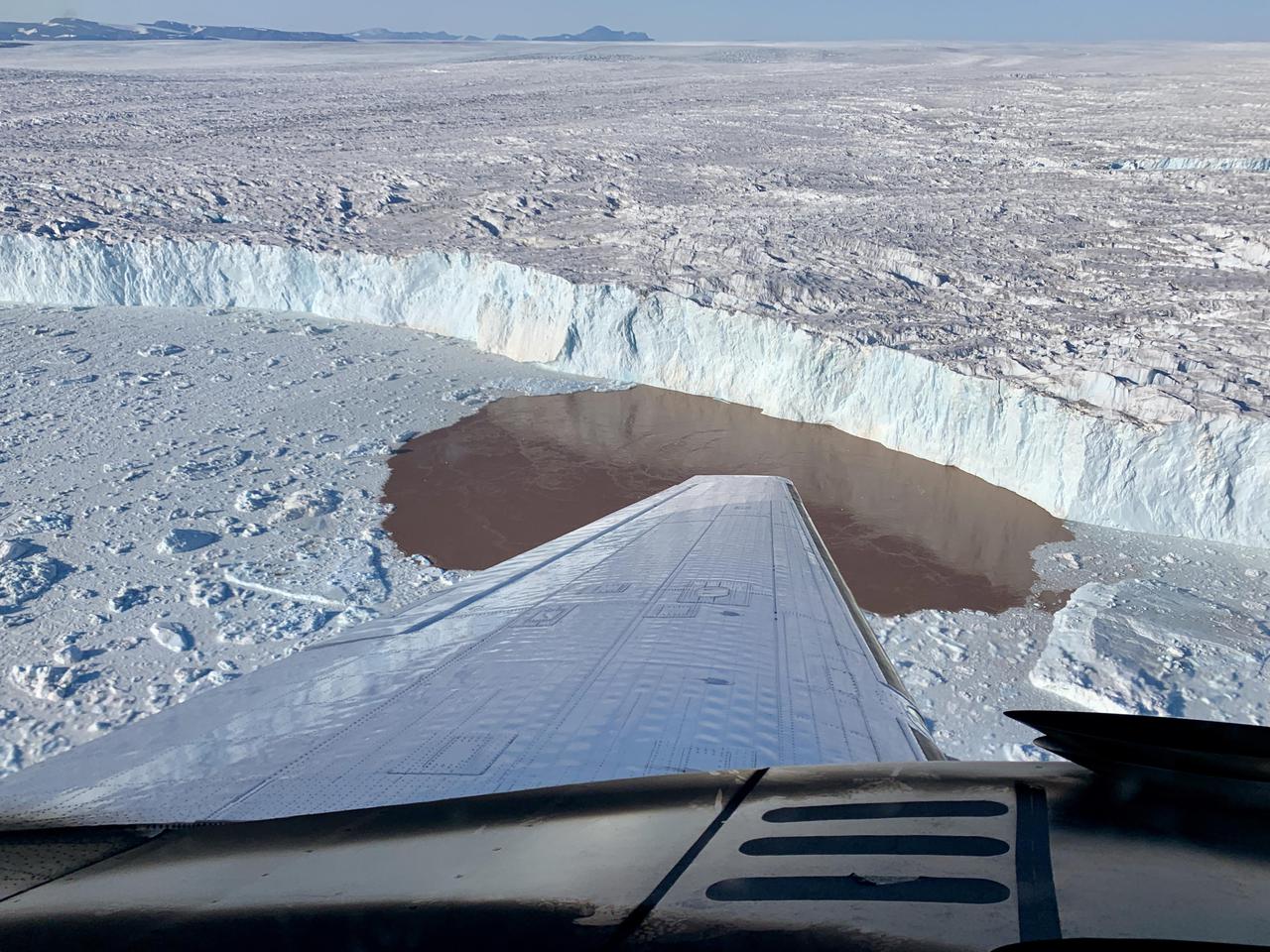 In this aerial view, a glacier along Greenland's craggy coastline is actively undergoing undercutting, a process in which meltwater flowing out from the bottom of the glacier enters the fjord. The brown water in front of the glacier is caused by sediment being dredged up from the base of the glacier by meltwater plumes reaching the surface of the fjord.  Because the meltwater contains no salt, it is lighter and rises through the saltier ocean water, dragging the warm ocean water into contact with the ice at the glacier's base. The result is increased melting at the bottom of the glacier, which creates and overhanging layer of ice that breaks off (or calves) as icebergs. As the climate warms, the ocean water temperature and the amount of meltwater both increase, combining to hasten this undercutting process and speed up the ice loss from Greenland's Ice Sheet.  The image was taken on Aug. 25, 2019 by a probe-dropping airplane as part of the Oceans Melting Greenland (OMG) mission. OMG has been studying glaciers that plunge into Greenland's steep-sided inlets, or fjords, for the past five years, gathering precise measurements of fjord depth and water salinity from probes dropped by plane, supplemented by measurements made by boat. The aim is to better understand how the warming ocean water around Greenland is hastening ice melt and calving of these marine-terminating glaciers.  https://photojournal.jpl.nasa.gov/catalog/PIA24162