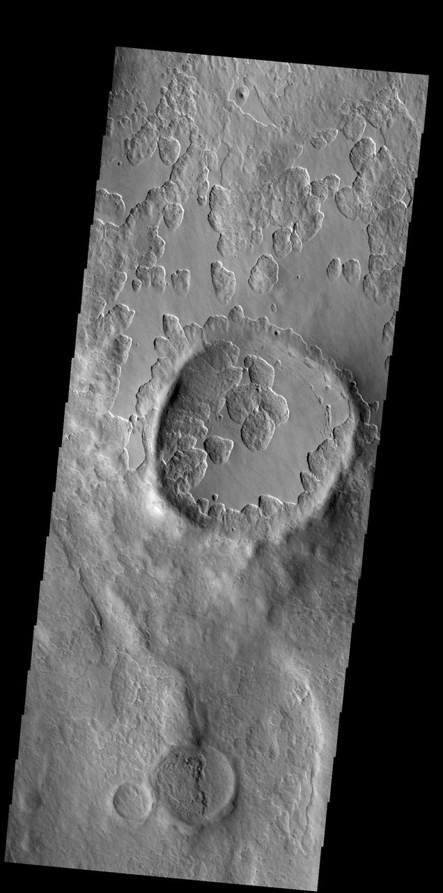 An unusual layer of smooth material covers the flanks of the volcano Peneus Patera just south of the Hellas Basin. Though smooth on its upper surface, the layer is pitted by a process of erosion that produces steep scarps facing the south pole and more gentle slopes in the direction of the equator. The style of erosion of the smooth layer suggests that ice of some form plays a role in shaping this terrain. Orbit Number: 83810 Latitude: -57.2811 Longitude: 54.3276 Instrument: VIS Captured: 2020-11-05 04:51 https://photojournal.jpl.nasa.gov/catalog/PIA24289
