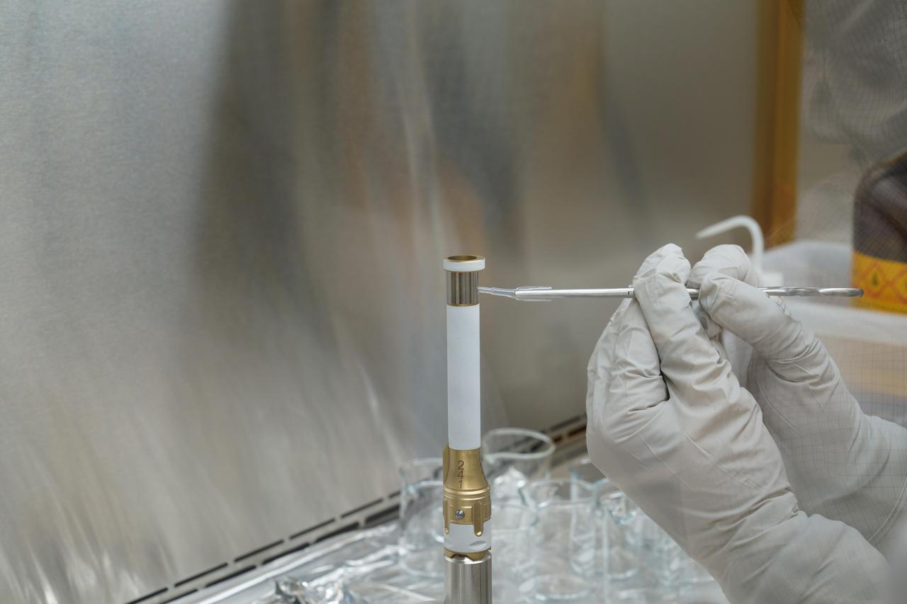 A technician working on the Mars 2020 Perseverance rover mission takes a sample from the surface of sample tube 241 to test for contamination. Each sample tube has its own unique serial number (seen on the gold-colored portion of the tube). The image was taken in a clean room facility at NASA's Jet Propulsion Laboratory in Southern California, where the tubes were developed and assembled.  https://photojournal.jpl.nasa.gov/catalog/PIA24294