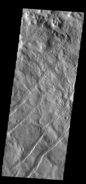 The linear depressions in this VIS image are tectonic graben. These graben are called Icaria Fossae and are located in Terra Sirenum. Graben are created in regions of extensional tectonic stress, where the bedrock is faulted and pulled apart, allowing linear sections of the surface to drop downward along paired faults. Orbit Number: 83941 Latitude: -43.6426 Longitude: 238.128 Instrument: VIS Captured: 2020-11-15 23:39 https://photojournal.jpl.nasa.gov/catalog/PIA24353