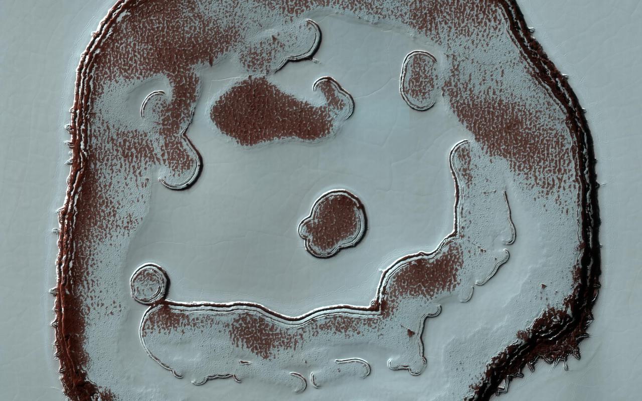 We've monitored the so-called Happy Face Crater in the south polar region of Mars for almost a decade. Two images that we took, one in 2011 and the other in 2020, at roughly the same season, show color variations that are due to different amounts of bright frost over darker red ground. The "blobby" features in the polar cap are due to the sun sublimating away the carbon dioxide into these round patterns. You can see how nine years of this thermal erosion have made the "mouth" of the face larger. The "nose" consisted of a two circular depressions in 2011, and in 2020, those two depressions have grown larger and merged. Measuring these changes throughout the Martian year help scientists understand the annual deposition and removal of polar frost, and monitoring these sites over long periods helps us understand longer term climate trends on the Red Planet. https://photojournal.jpl.nasa.gov/catalog/PIA24389