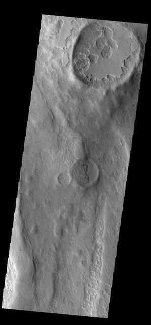 An unusual layer of smooth material covers the flanks of the volcano Peneus Patera just south of the Hellas Basin, seen here in a crater on the patera rim. Though smooth on its upper surface, the layer is pitted by a process of erosion that produces steep scarps facing the south pole and more gentle slopes in the direction of the equator. The style of erosion of the smooth layer suggests that ice of some form plays a role in shaping this terrain. Orbit Number: 84409 Latitude: -57.5964 Longitude: 54.2339 Instrument: VIS Captured: 2020-12-24 12:31 https://photojournal.jpl.nasa.gov/catalog/PIA24400