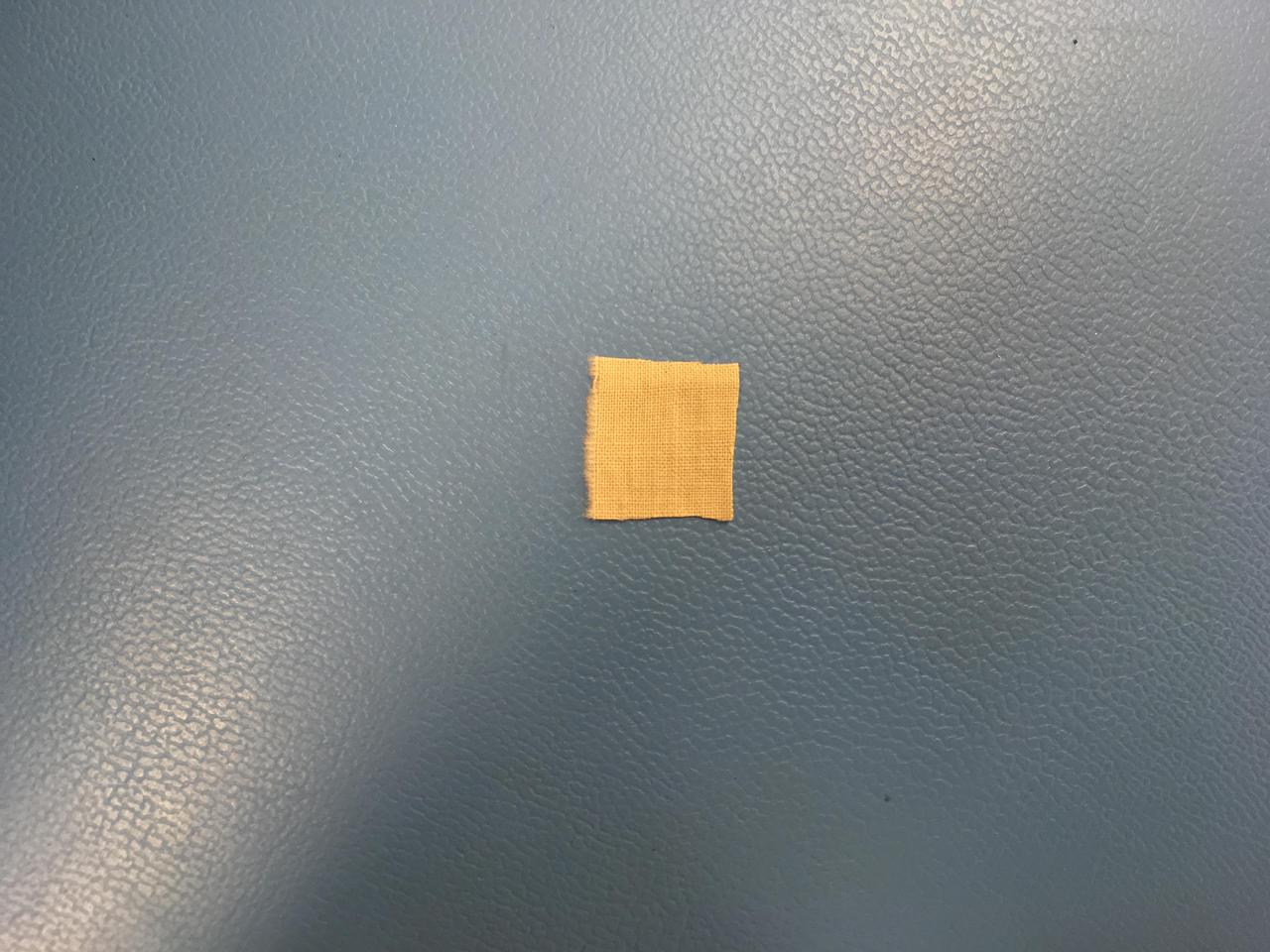 This 0.5-inch x 0.5-inch (1.3 x 1.3 centimeter) square of unbleached muslin material from the Wright brothers' first airplane was encapsulated in a protective polyamide film before being attached to a cable underneath the solar panel of NASA's Ingenuity Mars Helicopter. Procured by the Wrights from a local department store in downtown Dayton, Ohio, the cotton fabric (called "Pride of the West Muslin") was at the time mostly used for ladies undergarments. In the front parlor of their home, the Wrights cut the material into strips and used the family sewing machine to create wing coverings for their airplane Flyer 1, which achieved the first powered, controlled flight on Earth on Dec. 17, 1903.  The swatch of material from the Wright brothers' first airplane was obtained from the Carillon Historical Park, in Dayton, Ohio — home to the Wright Brothers National Museum. The image was taken in a clean room at NASA's Jet Propulsion Laboratory on January 15, 2020.  https://photojournal.jpl.nasa.gov/catalog/PIA24438