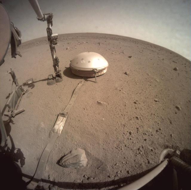 NASA's InSight lander used the scoop on its robotic arm to begin trickling soil over the cable connecting its seismometer to the spacecraft on March 14, 2021, the 816th Martian day, or sol of the mission. Scientists hope this make it easier to detect marsquakes by helping to insulate the cable from the wind and from the extreme temperature shifts that cause the cable to expand and contract. Animation available at https://photojournal.jpl.nasa.gov/catalog/PIA24450