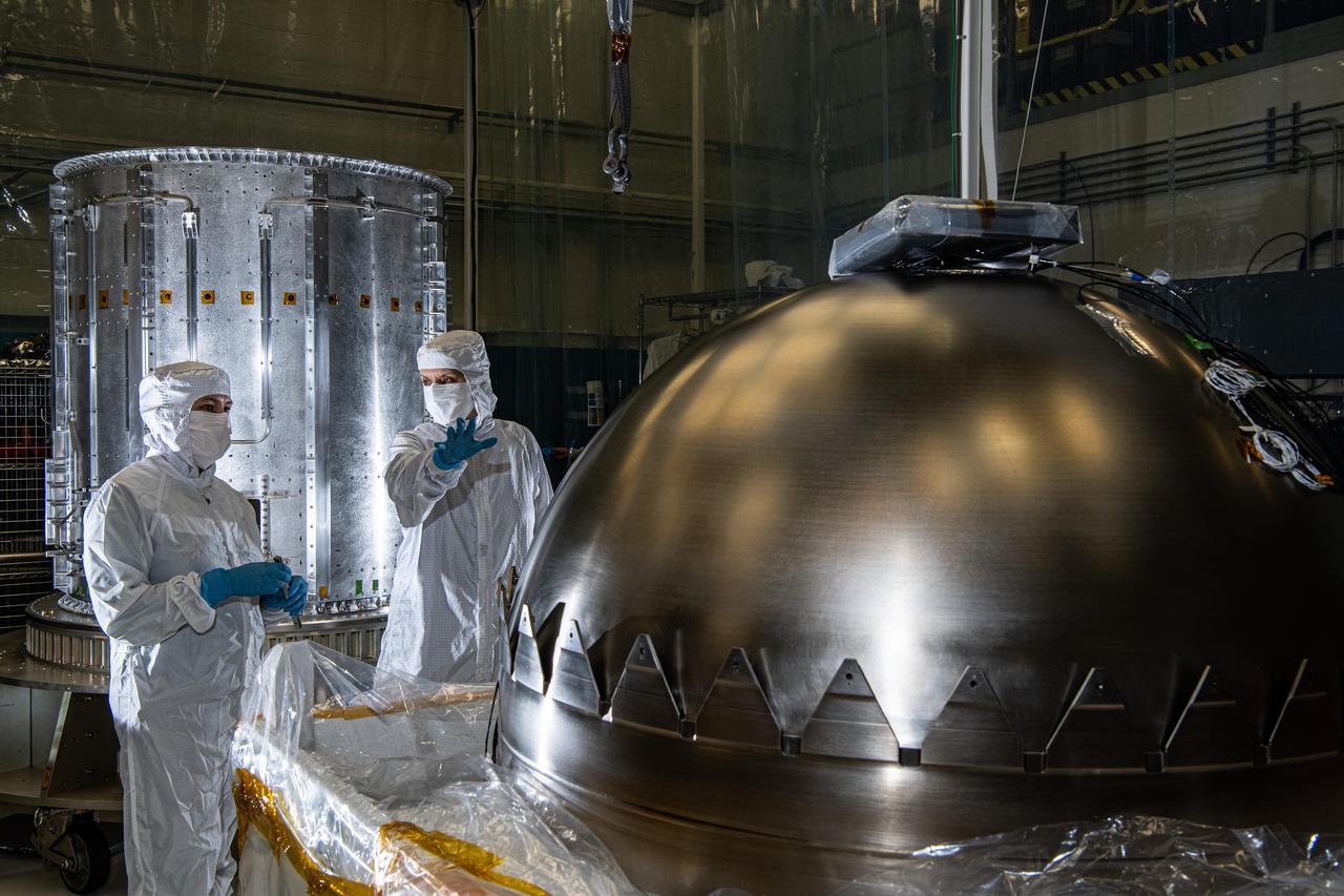 Contamination control engineers in a clean room at NASA's Goddard Space Flight Center in Greenbelt, Maryland, evaluate a propellant tank before it is installed in NASA's Europa Clipper spacecraft. The tank is one of two that will be used to hold the spacecraft's propellant. It will be inserted into the cylinder seen at left in the background, one of two cylinders that make up the propulsion module.  With an internal global ocean under a thick layer of ice, Jupiter's moon Europa may have the potential to harbor existing life. Europa Clipper will swoop around Jupiter on an elliptical path, dipping close to the moon on each flyby to collect data. Understanding Europa's habitability will help scientists better understand how life developed on Earth and the potential for finding life beyond our planet. Europa Clipper is set to launch in 2024.  https://photojournal.jpl.nasa.gov/catalog/PIA24478