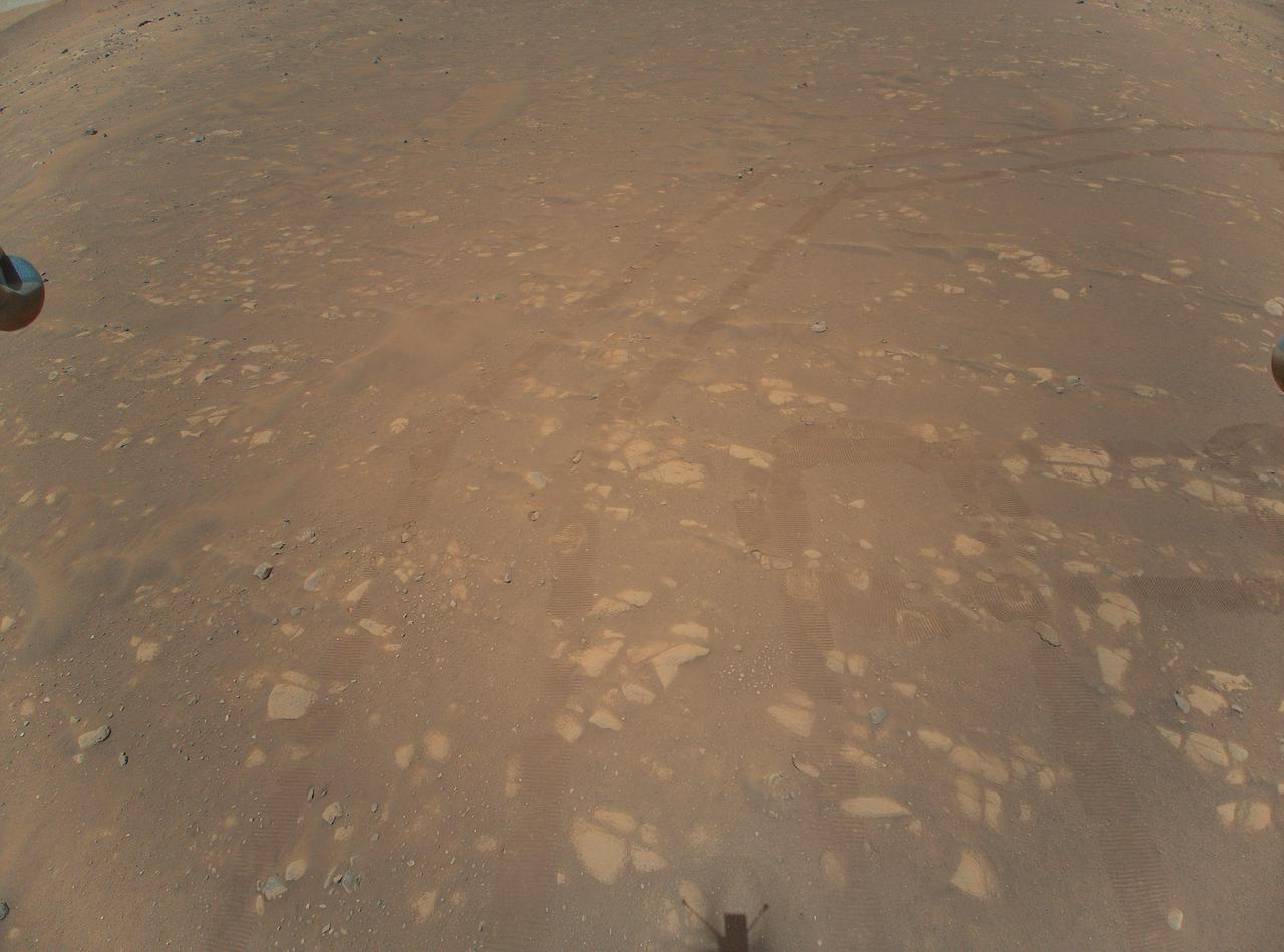 This is the second color image taken by NASA's Ingenuity helicopter. It was snapped on the helicopter's second flight, on April 22, 2021, from an altitude of about 17 feet (5.2 meters). Tracks made by NASA's Perseverance Mars rover can be seen as well.  https://photojournal.jpl.nasa.gov/catalog/PIA24500