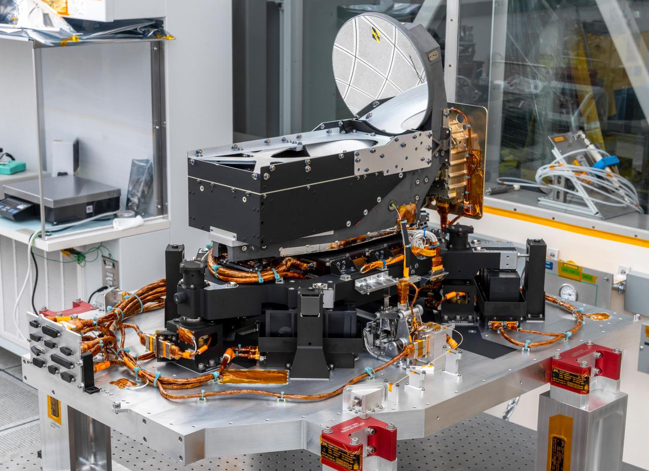 The Deep Space Optical Communications (DSOC) technology demonstration's flight laser transceiver is shown at NASA's Jet Propulsion Laboratory in Southern California in April 2021, before being installed inside its box-like enclosure that was later integrated with NASA's Psyche spacecraft. The transceiver consists of a near-infrared laser transmitter to send high-rate data to Earth, and a sensitive photon-counting camera to receive ground-transmitted low-rate data. The transceiver is mounted on an assembly of struts and actuators – shown in this photograph – that stabilizes the optics from spacecraft vibrations.  The DSOC experiment is the agency's first demonstration of optical communications beyond the Earth-Moon system. DSOC is a system that consists of this flight laser transceiver, a ground laser transmitter, and a ground laser receiver. New advanced technologies have been implemented in each of these elements. The transceiver will "piggyback" on NASA's Psyche spacecraft when it launches in August 2022 to the metal-rich asteroid of the same name. The DSOC technology demonstration will begin shortly after launch and continue as the spacecraft travels from Earth to its gravity-assist flyby of Mars.  https://photojournal.jpl.nasa.gov/catalog/PIA24569