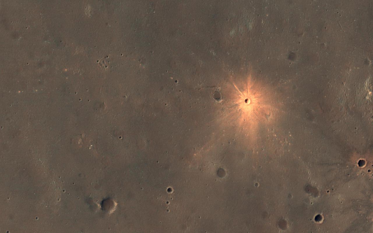 The Context Camera onboard MRO has been discovering new impact sites on Mars, followed up with HiRISE images. Usually these sites are discovered as new dark spots from removal or disturbance of bright dust, but a few show up as new bright spots. These craters may have bright ejecta from exposure of shallow subsurface materials, below a thin dark cover. An alternate theory—that this is a particle size effect—is unlikely because the bright materials are also distinctly redder than surrounding areas, and because ejecta is typically more coarse-grained, which would make the surface darker rather than brighter. The new crater visible here is about 13 meters in diameter. The color has been enhanced for this cutout. https://photojournal.jpl.nasa.gov/catalog/PIA24619