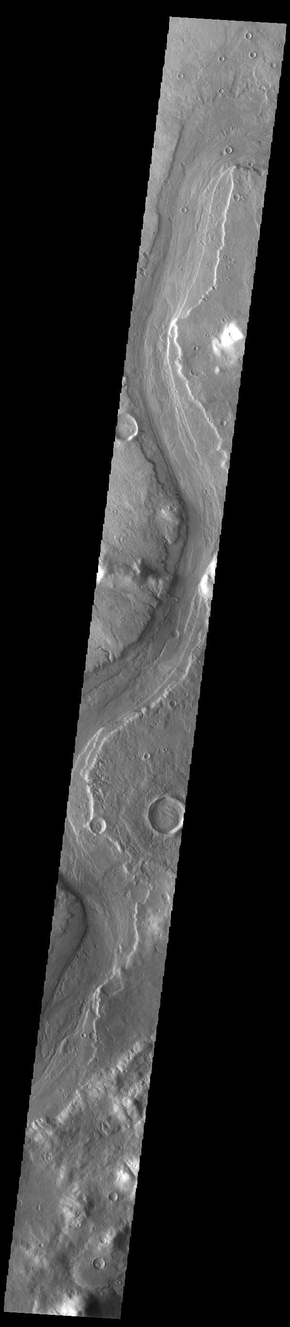 This VIS image shows a long section of Reull Vallis. Reull Vallis starts in Promethei Terra and empties into Hellas Plainitia. On the floor of this channel are ridged and grooved materials that seem to deflect around obstacles. These features are proposed to be ice-rich materials similar to glaciers on Earth. Reull Vallis is 1051km (653 miles) long.  Orbit Number: 84794 Latitude: -38.2433 Longitude: 111.672 Instrument: VIS Captured: 2021-01-25 05:11  https://photojournal.jpl.nasa.gov/catalog/PIA24716