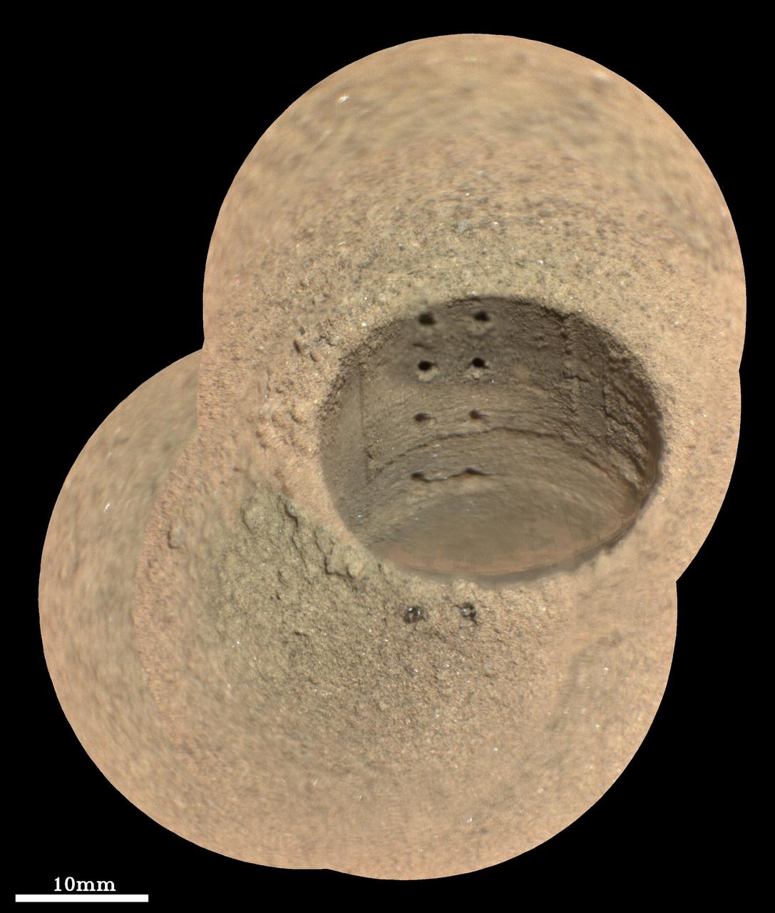 This composite image, made from four taken by the SuperCam instrument aboard NASA's Perseverance rover on August 8, 2021, shows the hole in a Martian rock where the rover attempted to collect its first sample; the small pits within it were created by laser zaps from SuperCam during subsequent efforts to analyze the rock's composition. The rover science team has nicknamed the drill hole "Roubion." The team believes that because of this rock's unusual composition, the process of extracting a core created a significant pile of tailings (or cuttings) around the coring hole. Eight pits produced by 30 laser shots each are seen in two columns inside the drill hole. The SuperCam team's analysis suggests that the top six pits penetrated the compacted mound of tailings around the hole, while the bottom two pits in the hole interrogated material below the rock surface. Two additional laser pits can be seen in the tailings at the near side of the hole. Two vertical ridges inside the hole – one on each side of the laser pits – were produced as the drill was removed, prior to laser analysis. Some bright mineral grains can be seen as glints in the tailings and in the drill hole. A few clumps or larger pieces of material are seen at the top of the tailings pile just to the left of the hole. The SuperCam images were taken from a distance of 7.32 feet (2.23 meters). A scale bar is included in this image. Perseverance landed in Mars' Jezero Crater on February 18, 2021, and has been exploring the floor of the crater since. At the time these images were taken, Perseverance was in an area nicknamed the "Crater Floor Fractured Rough" area. SuperCam is led by Los Alamos National Laboratory in New Mexico, where the instrument's Body Unit was developed. That part of the instrument includes several spectrometers as well as control electronics and software. The Mast Unit, including the Remote Microscopic Imager used for these images, was developed and built by several laboratories of the CNRS (the French research center) and French universities under the contracting authority of Centre National d'Etudes Spatiales (CNES, the French space agency). A key objective for Perseverance's mission on Mars is astrobiology, including the search for signs of ancient microbial life. The rover will characterize the planet's geology and past climate, pave the way for human exploration of the Red Planet, and be the first mission to collect and cache Martian rock and regolith (broken rock and dust). Subsequent NASA missions, in cooperation with ESA (European Space Agency), would send spacecraft to Mars to collect these sealed samples from the surface and return them to Earth for in-depth analysis. The Mars 2020 Perseverance mission is part of NASA's Moon to Mars exploration approach, which includes Artemis missions to the Moon that will help prepare for human exploration of the Red Planet. Movie available at https://photojournal.jpl.nasa.gov/catalog/PIA24749