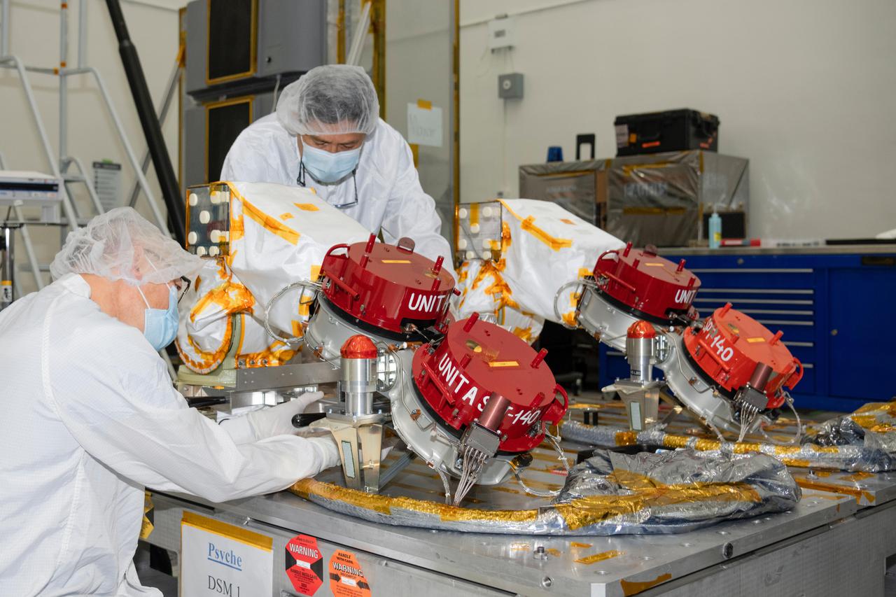 Engineers at NASA's Jet Propulsion Laboratory in Southern California prepare to integrate four Hall thrusters (beneath red protective covers) into the agency's Psyche spacecraft in July 2021.  Psyche is set to launch in August 2022 and will travel to its target, a metal-rich asteroid also named Psyche, under the power of solar electric propulsion. This super-efficient mode of propulsion uses solar arrays to capture sunlight that is converted into electricity to power the spacecraft's thrusters. The thrusters work by turning xenon gas, a neutral gas used in car headlights and plasma TVs, into xenon ions. As the xenon ions are accelerated out of the thruster, they create the thrust that will propel the spacecraft.  On the Psyche spacecraft, Hall thrusters will be used for the first time beyond lunar orbit, demonstrating that they could play a role in supporting future missions to deep space.  https://photojournal.jpl.nasa.gov/catalog/PIA24788