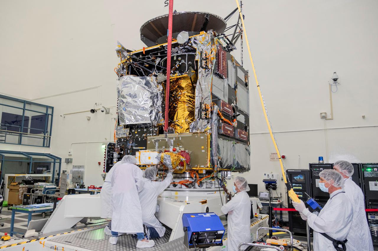 Engineers at NASA's Jet Propulsion Laboratory in Southern California work to integrate Hall thrusters into the agency's Psyche spacecraft in this July 2021 photo. One of the thrusters is visible on the side of the spacecraft beneath a red protective cover.  Psyche is set to launch in August 2022 and will travel to its target, a metal-rich asteroid also named Psyche, under the power of solar electric propulsion. This super-efficient mode of propulsion uses solar arrays to capture sunlight that is converted into electricity to power the spacecraft's Hall thrusters. They work by turning xenon gas, a neutral gas used in car headlights and plasma TVs, into xenon ions. As the xenon ions are accelerated out of the thruster, they create the thrust that will propel the spacecraft.  This will be the first use of Hall thrusters beyond lunar orbit, demonstrating that they could play a role in supporting future deep space missions.  https://photojournal.jpl.nasa.gov/catalog/PIA24789
