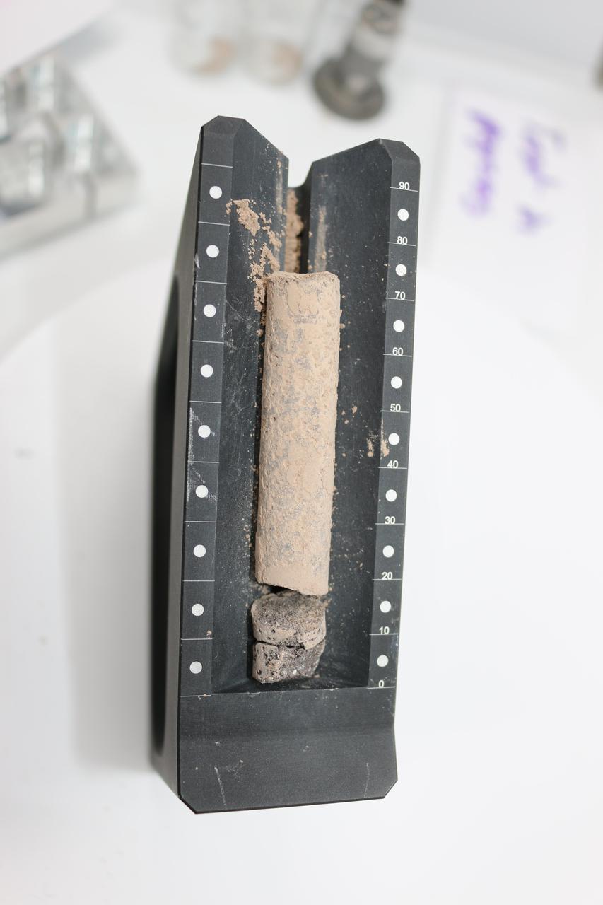This image shows a core, about 2.8 inches (71.1 millimeters) in length, collected from a basaltic rock during a test of the Perseverance rover's Sampling and Caching System at NASA's Jet Propulsion Laboratory in Southern California. After a sampling test is completed, engineers carefully remove the core from its sample tube and place it in a sample tray, as they've done here, to document the result.  A key objective for Perseverance's mission on Mars is astrobiology, including the search for signs of ancient microbial life. The rover will characterize the planet's geology and past climate, pave the way for human exploration of the Red Planet, and be the first mission to collect and cache Martian rock and regolith (broken rock and dust).  Subsequent NASA missions, in cooperation with ESA (European Space Agency), would send spacecraft to Mars to collect these sealed samples from the surface and return them to Earth for in-depth analysis.  The Mars 2020 Perseverance mission is part of NASA's Moon to Mars exploration approach, which includes Artemis missions to the Moon that will help prepare for human exploration of the Red Planet.  https://photojournal.jpl.nasa.gov/catalog/PIA24809