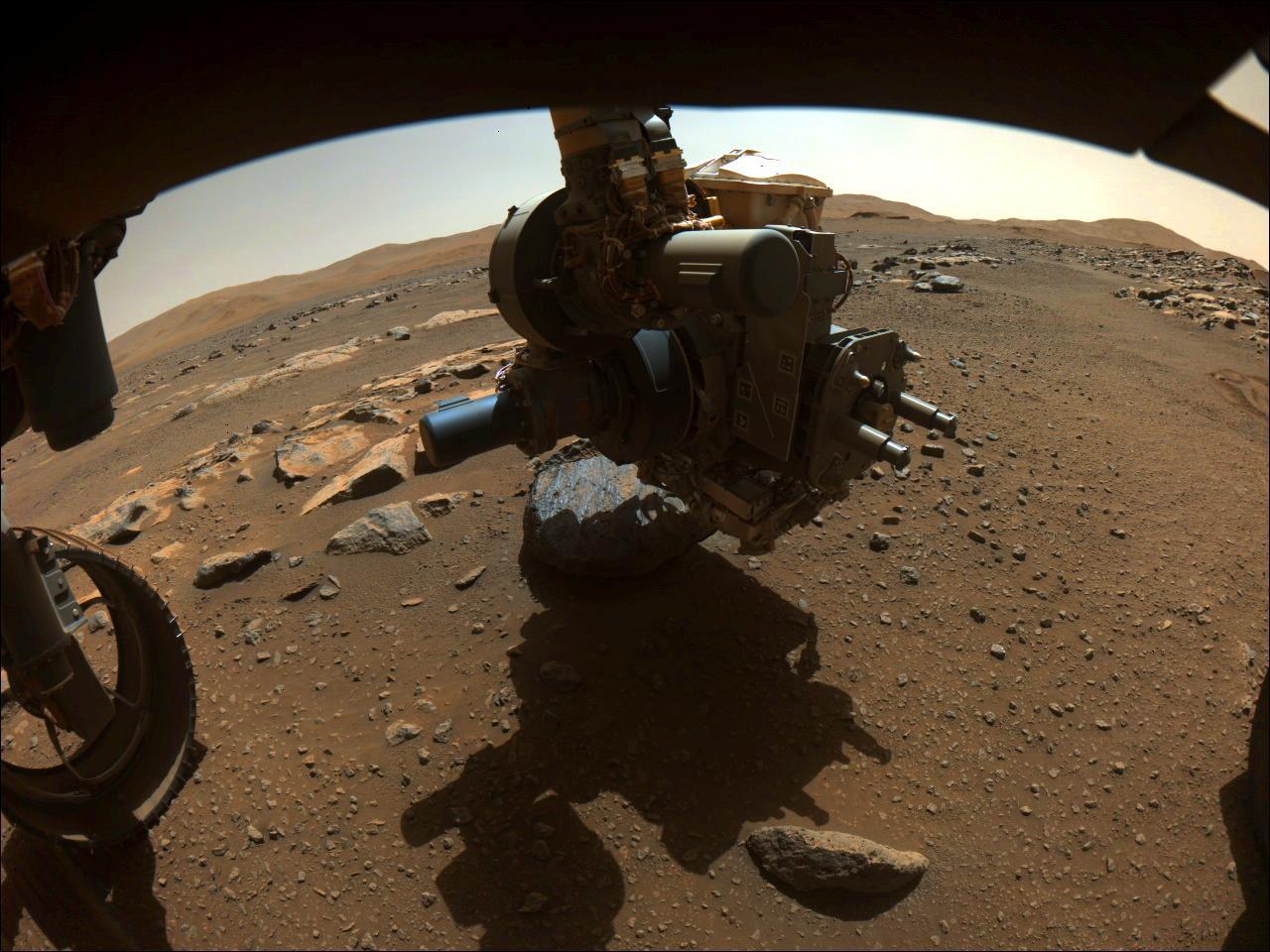 On Aug. 27, 2021, NASA's Perseverance rover captured this image of the science-instrument-laden turret at the end of its robotic arm getting close to the rock nicknamed "Rochette."  Perseverance had just abraded a circular patch, nicknamed "Bellegarde," of the rock. This image was taken when the SHERLOC (Scanning Habitable Environments with Raman and Luminescence for Organics and Chemicals) instrument on the turret was using its WATSON (Wide Angle Topographic Sensor for Operations and eNgineering) camera to take a close-up image of Bellegarde on the 185th sol (Martian day) of Perseverance's mission.  This image, taken by one of Perseverance's Hazard Avoidance Cameras, has been processed to enhance contrast.  A key objective for Perseverance's mission on Mars is astrobiology, including the search for signs of ancient microbial life. The rover will characterize the planet's geology and past climate, pave the way for human exploration of the Red Planet, and be the first mission to collect and cache Martian rock and regolith.  The Mars 2020 Perseverance mission is part of NASA's Moon to Mars exploration approach, which includes Artemis missions to the Moon that will help prepare for human exploration of the Red Planet.  Subsequent NASA missions, in cooperation with ESA (European Space Agency), would send spacecraft to Mars to collect these sealed samples from the surface and return them to Earth for in-depth analysis.  https://photojournal.jpl.nasa.gov/catalog/PIA24831