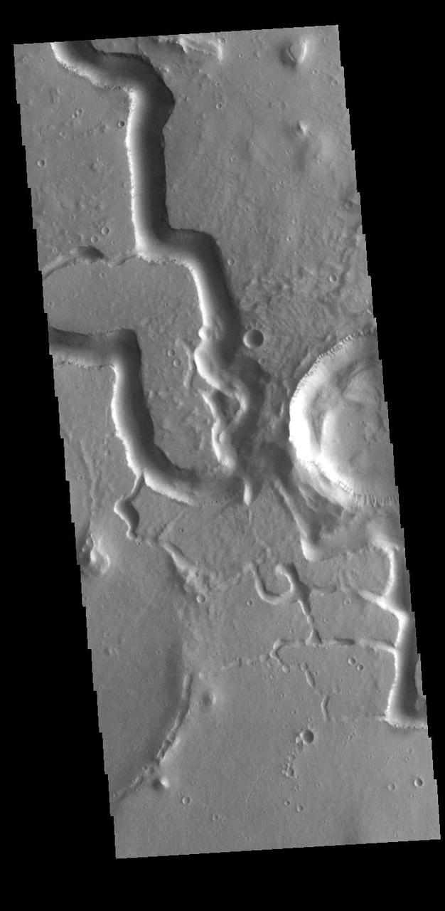 This VIS image is located in Utopia Planitia and shows part of Hephaestus Fossae. Hephaestus Fossae is a complex channel system. It has been proposed that the channel formed by the release of melted subsurface ice during an impact event that created a large crater south of this image. Additionally, the nearby Elysium volcanic center created subsurface heating that may have played a part in creating both Hephaestus Fossae and Hebrus Valles to the north. Orbit Number: 85623 Latitude: 19.0345 Longitude: 124.821 Instrument: VIS Captured: 2021-04-03 12:15 https://photojournal.jpl.nasa.gov/catalog/PIA24858