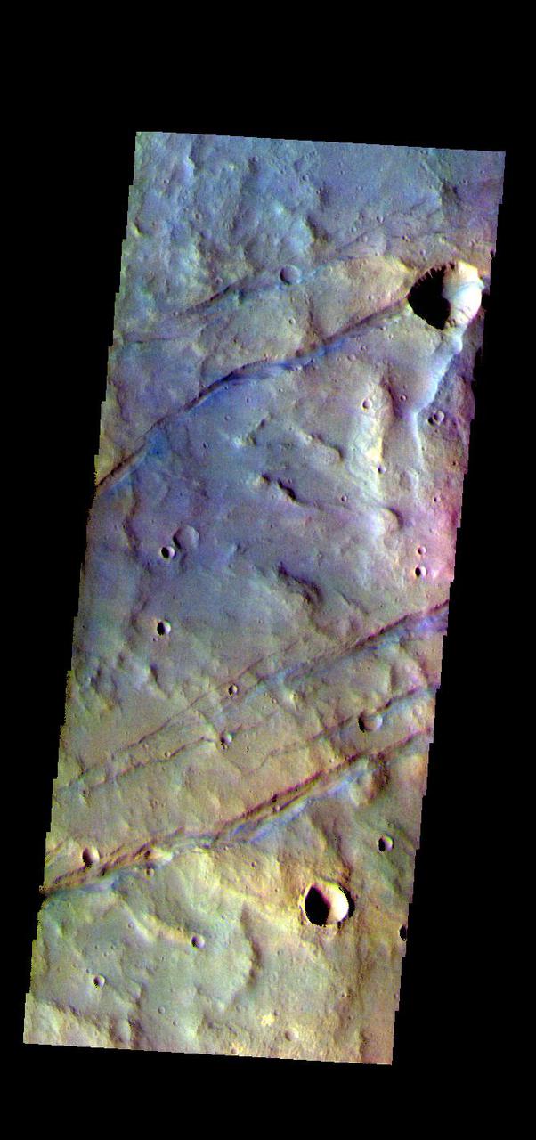 The THEMIS VIS camera contains 5 filters. The data from different filters can be combined in multiple ways to create a false color image. These false color images may reveal subtle variations of the surface not easily identified in a single band image. Today's false color image shows some of the graben that comprise Sirenum Fossae. The linear features, called graben, are created in regions of extensional tectonic stress, where the bedrock is faulted and pulled apart, allowing linear sections of the surface to drop downward along paired faults. The Sirenum Fossae graben are 2735km (1700 miles) long.  The THEMIS VIS camera is capable of capturing color images of the Martian surface using five different color filters. In this mode of operation, the spatial resolution and coverage of the image must be reduced to accommodate the additional data volume produced from using multiple filters. To make a color image, three of the five filter images (each in grayscale) are selected. Each is contrast enhanced and then converted to a red, green, or blue intensity image. These three images are then combined to produce a full color, single image. Because the THEMIS color filters don't span the full range of colors seen by the human eye, a color THEMIS image does not represent true color. Also, because each single-filter image is contrast enhanced before inclusion in the three-color image, the apparent color variation of the scene is exaggerated. Nevertheless, the color variation that does appear is representative of some change in color, however subtle, in the actual scene. Note that the long edges of THEMIS color images typically contain color artifacts that do not represent surface variation.  Orbit Number: 83743 Latitude: -37.2437 Longitude: 191.251 Instrument: VIS Captured: 2020-10-30 16:21  https://photojournal.jpl.nasa.gov/catalog/PIA25000