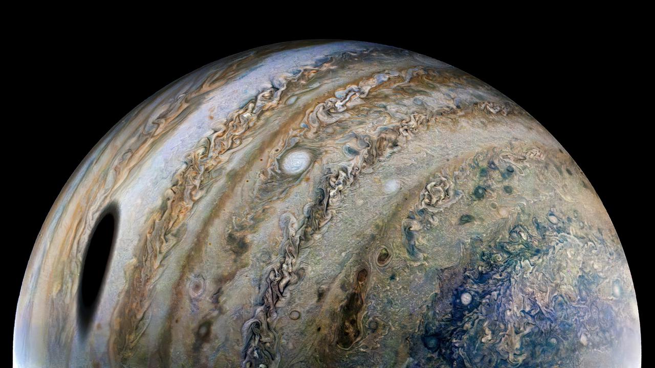 Citizen scientist Thomas Thomopoulos created this enhanced-color image using raw data from the JunoCam instrument. At the time the raw image was taken, the Juno spacecraft was about 44,000 miles (71,000 kilometers) above Jupiter's cloud tops, at a latitude of about 55 degrees south, and 15 times closer than Ganymede, which orbits about 666,000 miles (1.1 million kilometers) away from Jupiter.  An observer at Jupiter's cloud tops within the oval shadow would experience a total eclipse of the Sun. Total eclipses are more common on Jupiter than Earth for several reasons. Jupiter has four major moons (Galilean satellites) that often pass between Jupiter and the Sun: in seven days, Ganymede transits once; Europa, twice; and Io, four times. And since Jupiter's moons orbit in a plane close to Jupiter's orbital plane, the moon shadows are often cast upon the planet.  JunoCam captured this image from very close to Jupiter, making Ganymede's shadow appear especially large.   https://photojournal.jpl.nasa.gov/catalog/PIA25015