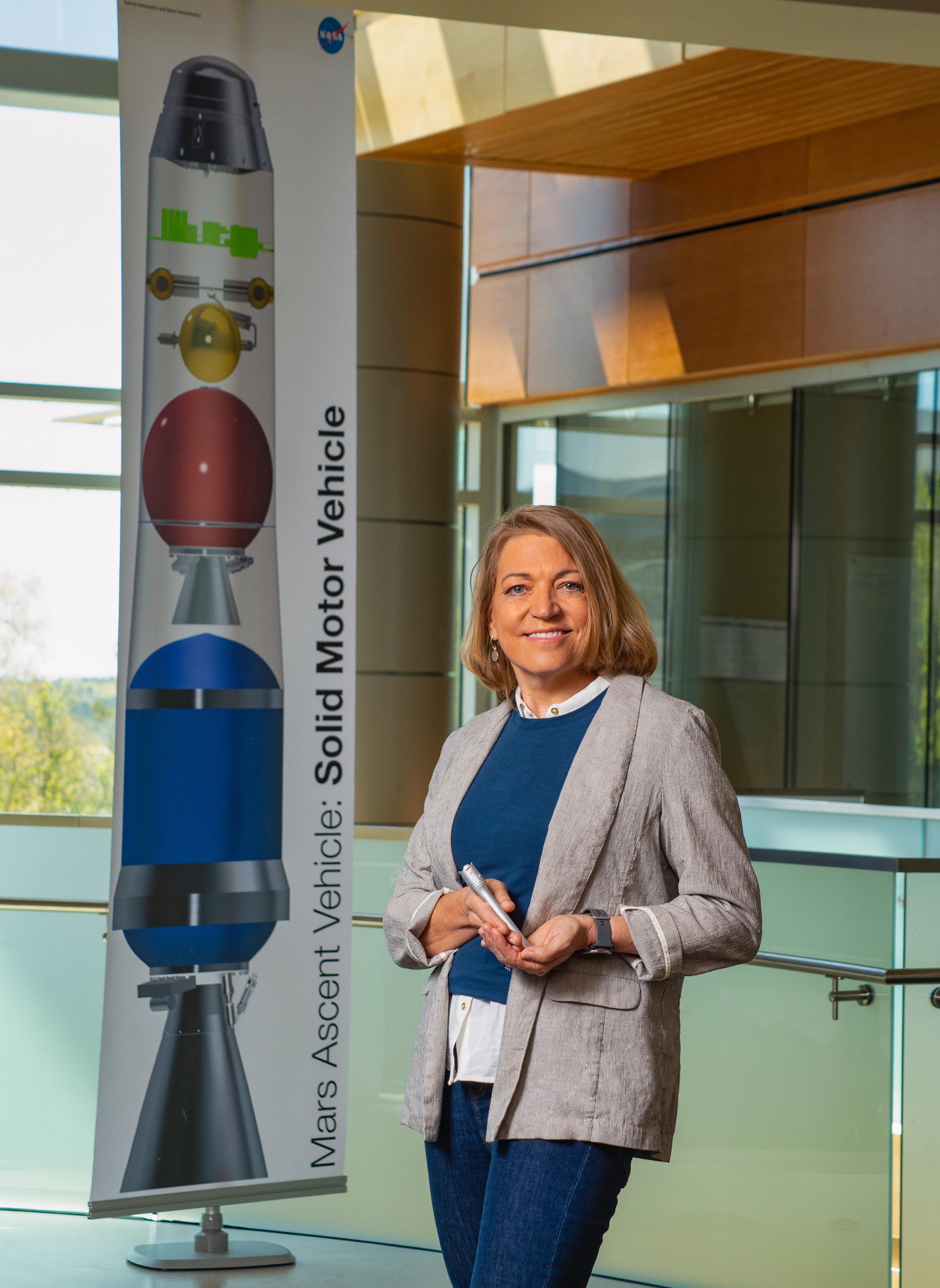 Angie Jackman, manager of the Mars Ascent Vehicle (MAV) project, holds a 3D-printed model of the tubes NASA's Perseverance rover is already filling with Martian rock and soil samples. Set to be the first rocket to launch from another planet, the MAV is designed to carry the sealed samples into orbit around Mars.  https://photojournal.jpl.nasa.gov/catalog/PIA25074