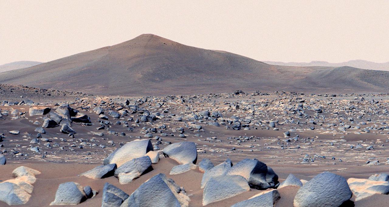 NASA's Perseverance Mars rover snapped this view of a hill in Mars' Jezero Crater called "Santa Cruz" on April 29, 2021, the 68th Martian day, or sol, of the mission. About 20 inches (50 centimeters) across on average, the boulders in the foreground are among the type of rocks the rover team has named "Ch'al" (the Navajo term for "frog" and pronounced "chesh"). Perseverance will return to the area in the next week or so.  Composed of multiple images, this enhanced-color mosaic was created using the left- and right-eye views of Perseverance's Mastcam-Z camera system, merging the scene into a single, wider view. Santa Cruz hill is a possible eroded remnant of Jezero Crater's western delta. The hill is about 164 feet (50 meters) tall and was roughly 1.6 miles (2.5 kilometers) east of the rover when the photo was taken, viewed from "Van Zyl Overlook."  A key objective for Perseverance's mission on Mars is astrobiology, including the search for signs of ancient microbial life. The rover will characterize the planet's geology and past climate, pave the way for human exploration of the Red Planet, and be the first mission to collect and cache Martian rock and regolith (broken rock and dust).  Subsequent NASA missions, in cooperation with ESA (European Space Agency), would send spacecraft to Mars to collect these sealed samples from the surface and return them to Earth for in-depth analysis.  The Mars 2020 Perseverance mission is part of NASA's Moon to Mars exploration approach, which includes Artemis missions to the Moon that will help prepare for human exploration of the Red Planet.  https://photojournal.jpl.nasa.gov/catalog/PIA25075