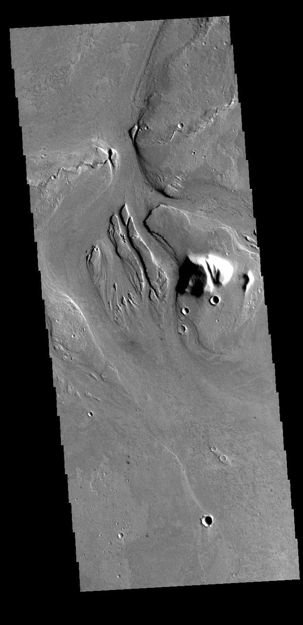 This VIS image shows part of Athabasca Valles. Several streamlined islands are visible, with 'tails' pointing downstream. Arising from Cerberus Fossae, the formation mode of this channel is still being debated. While the channel features are similar to water flow, other features are similar to lava flows, and yet other features have an appearance of slabs of material that floated on an underlying fluid. This is just one of the complex channel formations in the Elysium Planitia region. Orbit Number: 86820 Latitude: 7.69451 Longitude: 154.454 Instrument: VIS Captured: 2021-07-11 01:35 https://photojournal.jpl.nasa.gov/catalog/PIA25103