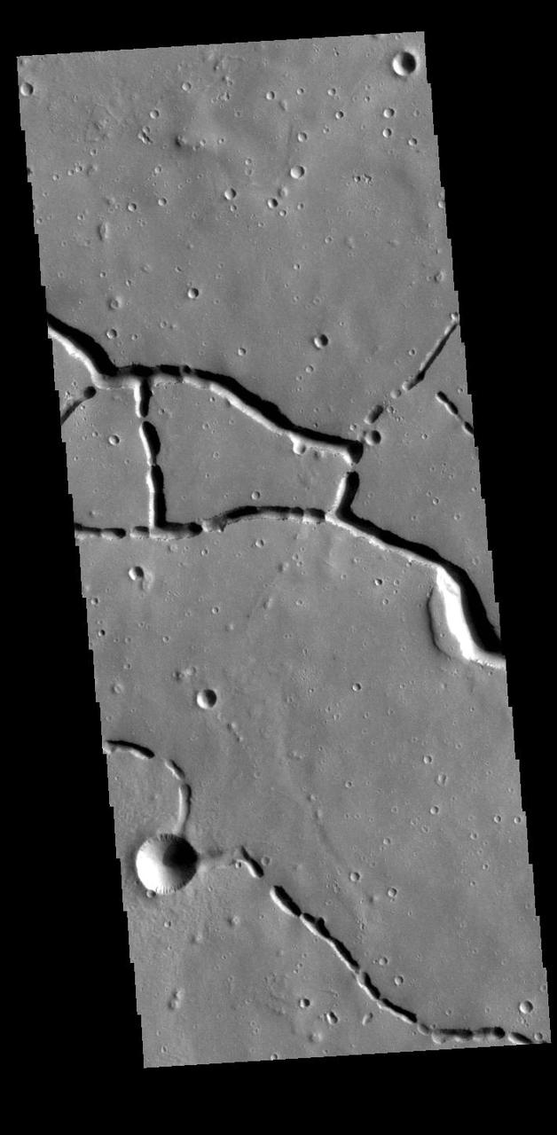 This VIS image is located in the northern portion of Hephaestus Fossae. Hephaestus Fossae is a complex channel system in Utopia Planitia near Elysium Mons. It has been proposed that the channels formed by the release of melted subsurface ice during the impact event that created a large crater southeast of this image. Additionally, the nearby Elysium volcanic center created subsurface heating that may have played a part in creating both Hephaestus Fossae and Hebrus Valles to the north. The right angle intersections indicate there is some tectonic activity in the region, and the circular depressions indicate surface collapse into subsurface voids. Hephaestus Fossae is a very complex set of features. Orbit Number: 88019 Latitude: 21.1587 Longitude: 122.646 Instrument: VIS Captured: 2021-10-17 19:02 https://photojournal.jpl.nasa.gov/catalog/PIA25111