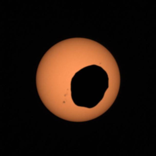NASA's Perseverance Mars rover used its Mastcam-Z camera system to shoot video of Phobos, one of Mars' two moons, eclipsing the Sun. It's the most zoomed-in, highest-frame-rate observation of a Phobos solar eclipse ever taken from the Martian surface.  Several Mars rovers have observed Phobos crossing in front of the Sun over the past 18 years. Spirit and Opportunity made the first observations in 2004; Curiosity in 2019 was the first to record video of the event. Each time these eclipses are observed, they allow scientists to measure subtle shifts in Phobos' orbit over time. The moon's tidal forces pull on the deep interior crust and mantle of the Red Planet; studying how much Phobos shifts over time reveals something about how resistant the crust and mantle are, and thus what kinds of materials they're made of.  It's long been known that Phobos is drifting toward the Martian surface year by year; tens of millions of years from now, it is expected to crash into the planet or fragment into chunks that will impact the planet. Studying Phobos' orbit also allows scientists to refine predictions of when the doomed moon will crash into Mars.  A key objective for Perseverance's mission on Mars is astrobiology, including the search for signs of ancient microbial life. The rover will characterize the planet's geology and past climate, pave the way for human exploration of the Red Planet, and be the first mission to collect and cache Martian rock and regolith (broken rock and dust).  Subsequent NASA missions, in cooperation with ESA (European Space Agency), would send spacecraft to Mars to collect these sealed samples from the surface and return them to Earth for in-depth analysis.  The Mars 2020 Perseverance mission is part of NASA's Moon to Mars exploration approach, which includes Artemis missions to the Moon that will help prepare for human exploration of the Red Planet.  Movie available at https://photojournal.jpl.nasa.gov/catalog/PIA25179